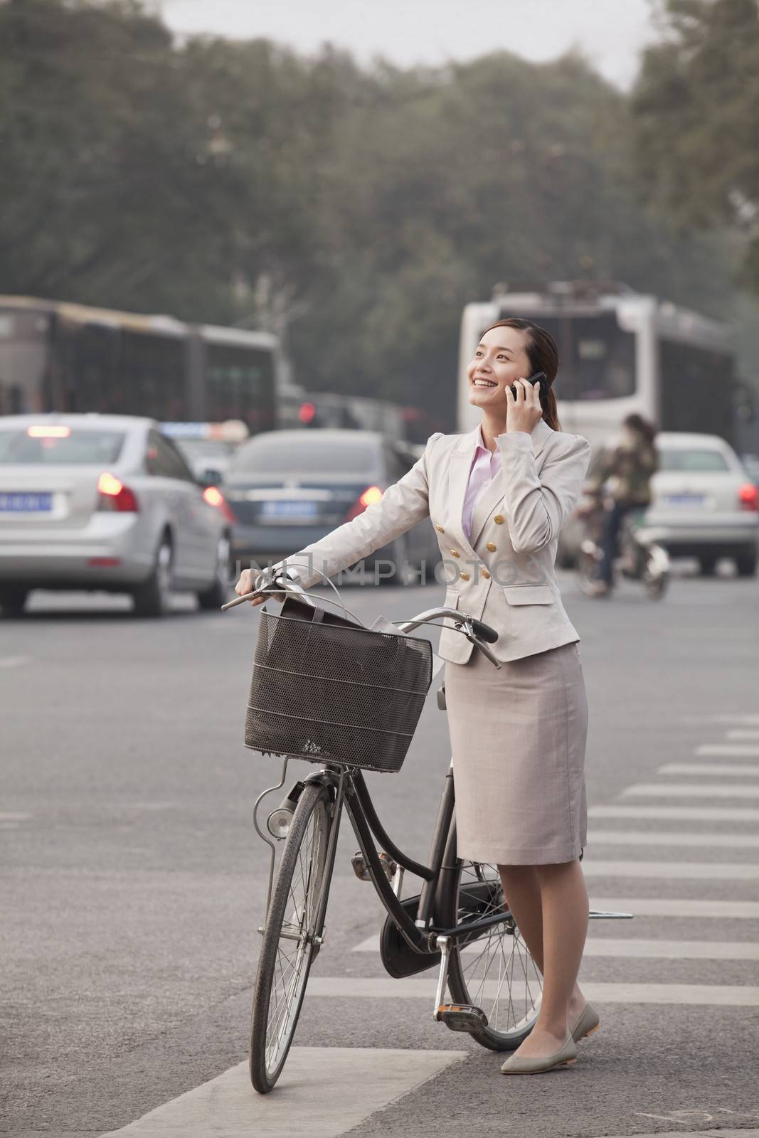 Young Business Woman standing with a Bicycle, Beijing, China by XiXinXing