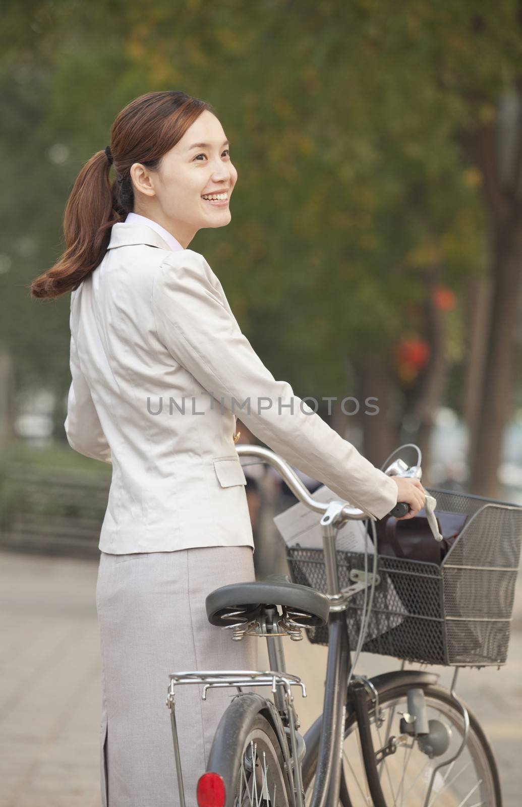 Young Business Woman standing with a Bicycle, Beijing, China