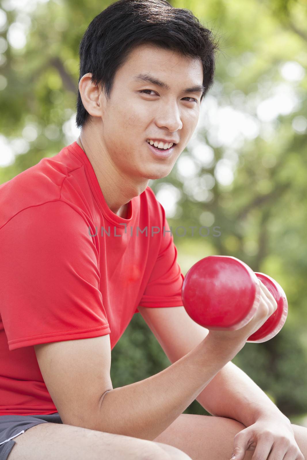 Young Man exercising with Dumbbell