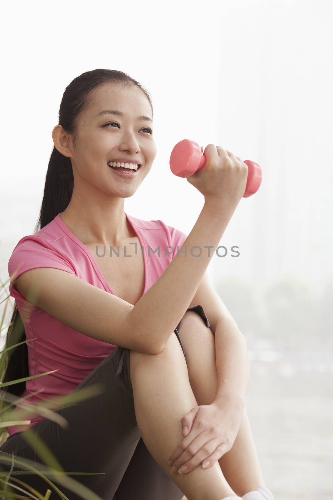 Young Woman Lifting Weights in the Park