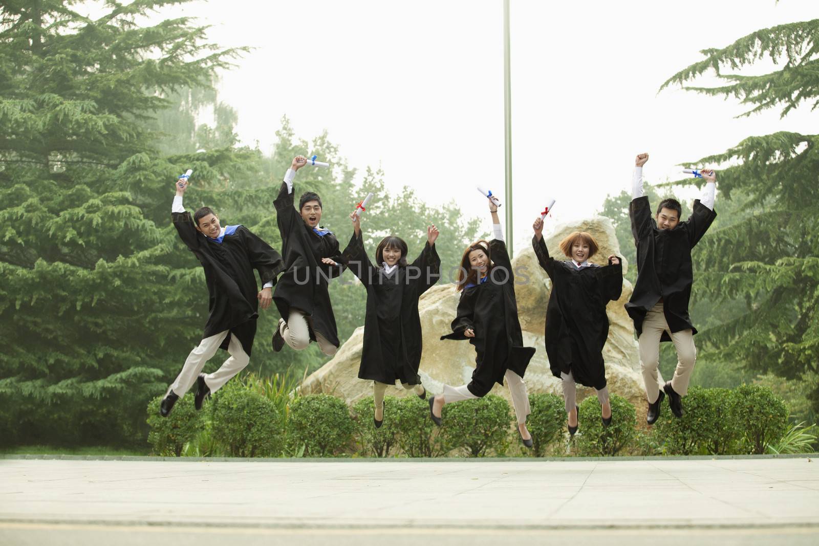 Young Group of Graduates Jumping
