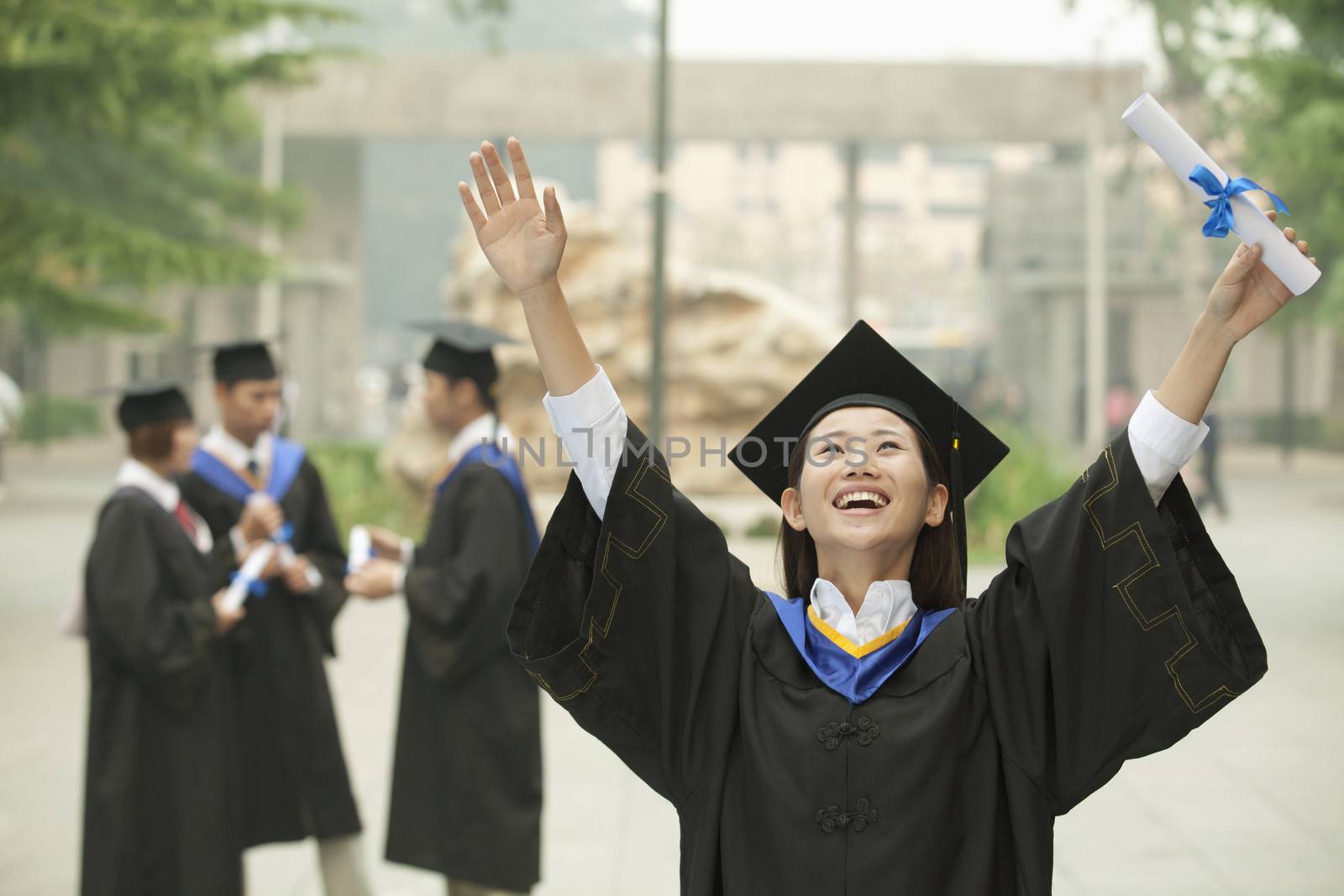 Young Female University Graduate, Arms Raised in the Air with Diploma by XiXinXing