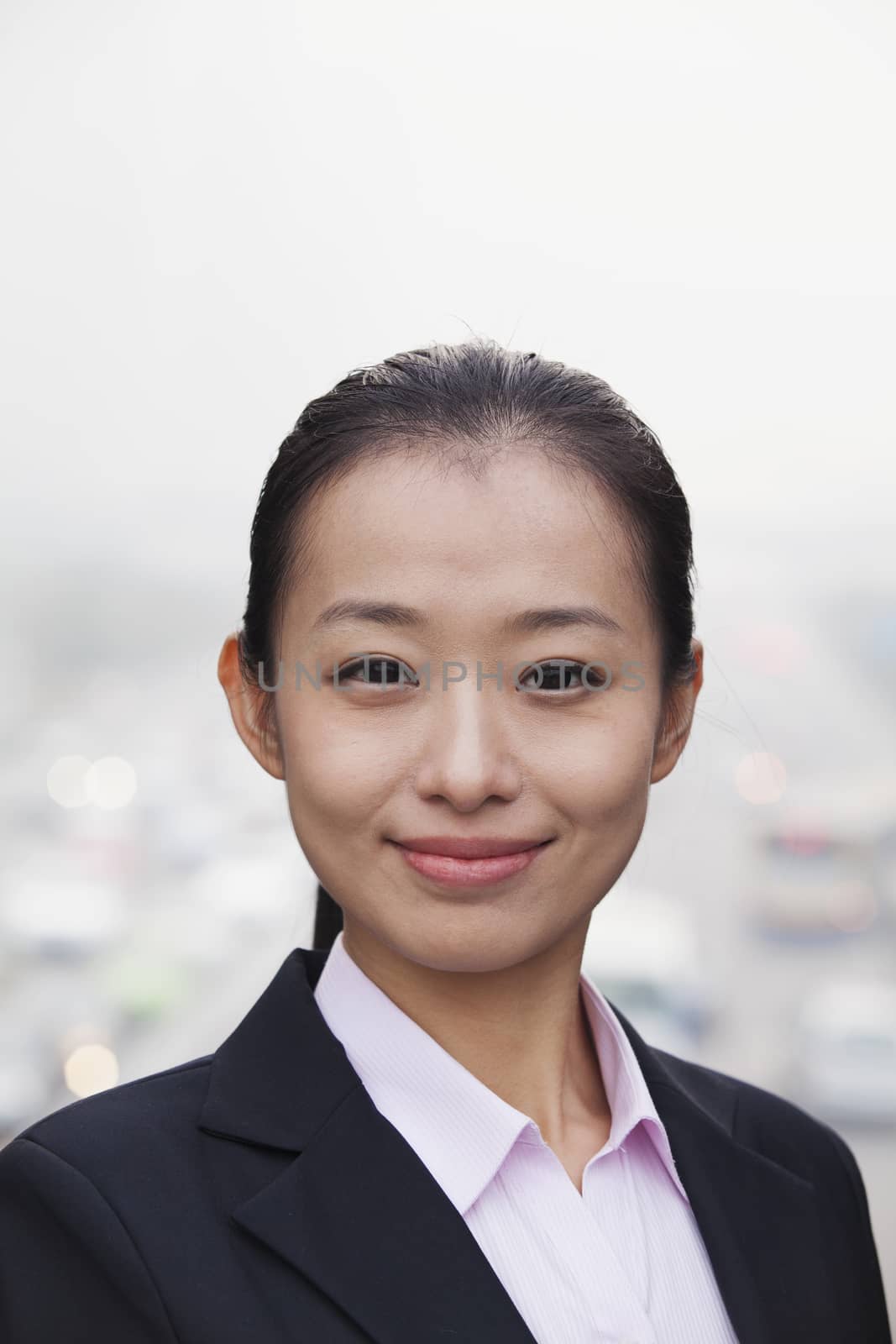 Portrait of Young Businesswoman Looking at Camera with Traffic Below