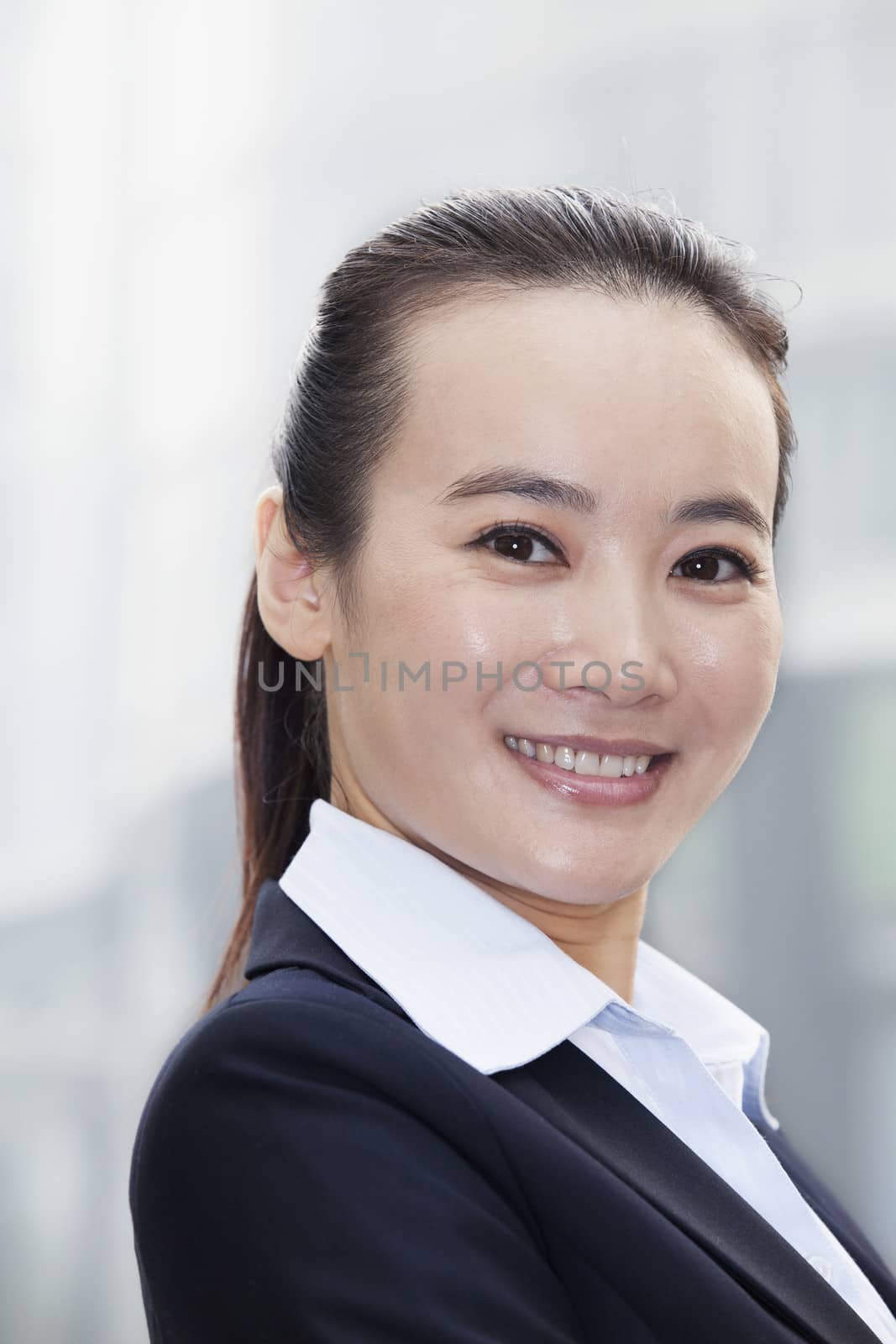Young Businesswoman Smiling and Looking At Camera Urban Setting