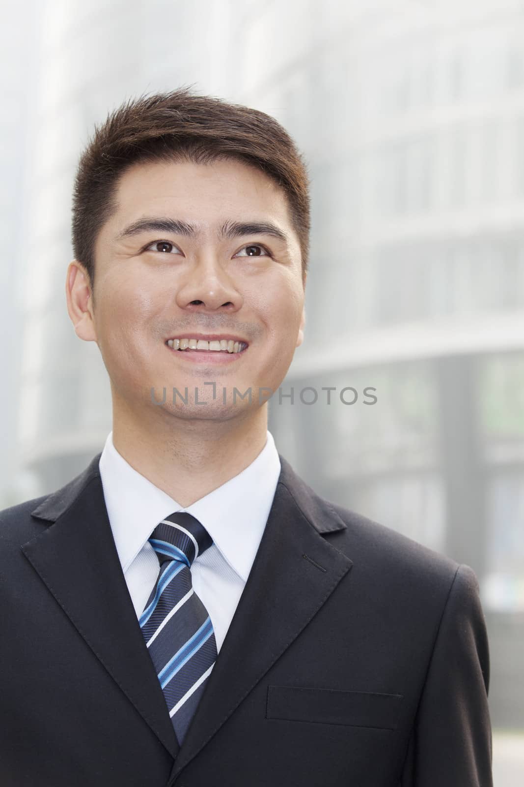 Young Businessman Smiling and Looking Up, Portrait by XiXinXing