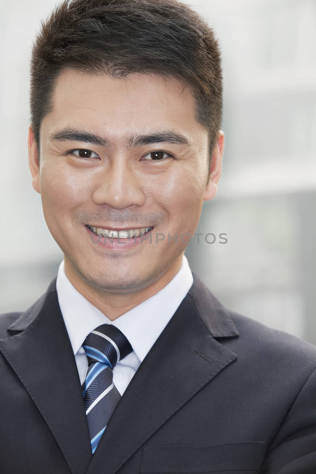 Young Businessman Smiling and Looking into Camera, Portrait by XiXinXing