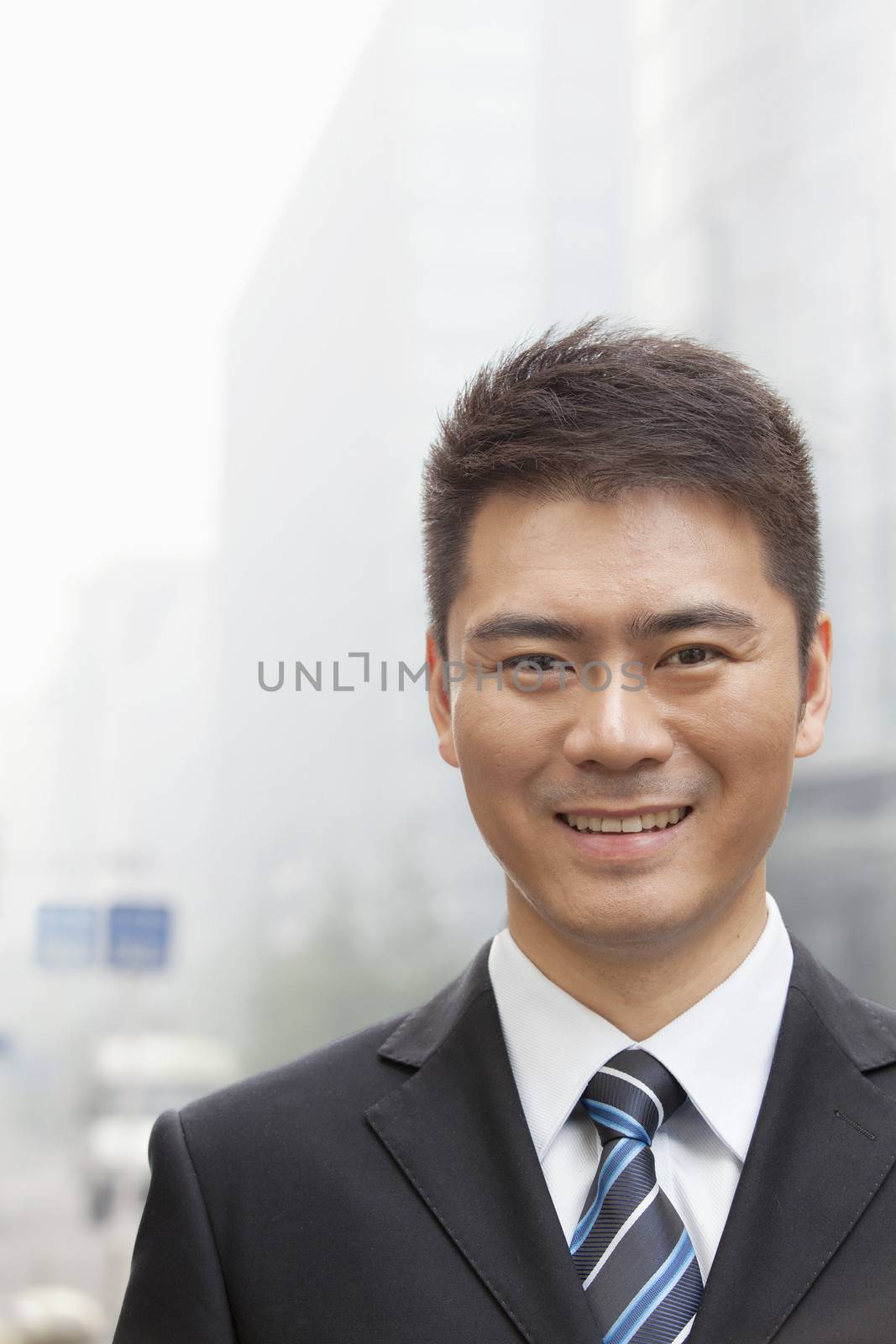 Young Businessman Smiling and Looking into Camera, Portrait