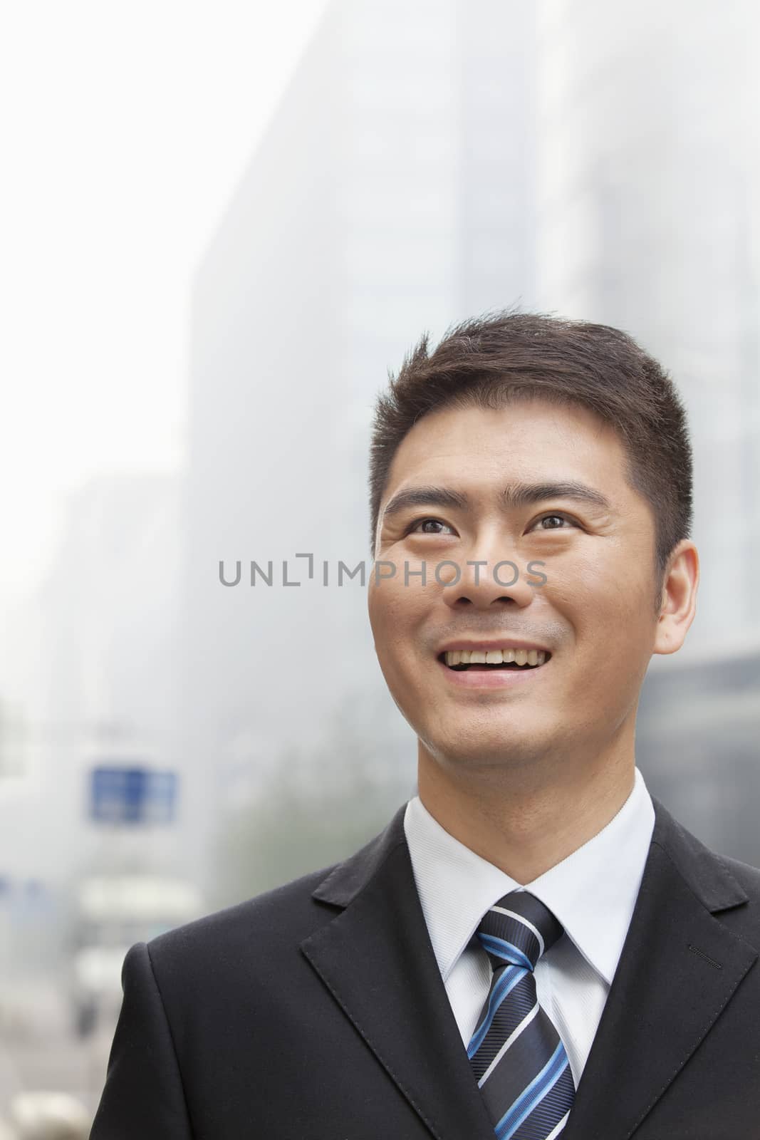 Young Businessman Smiling and Looking into the Distance, Portrait by XiXinXing