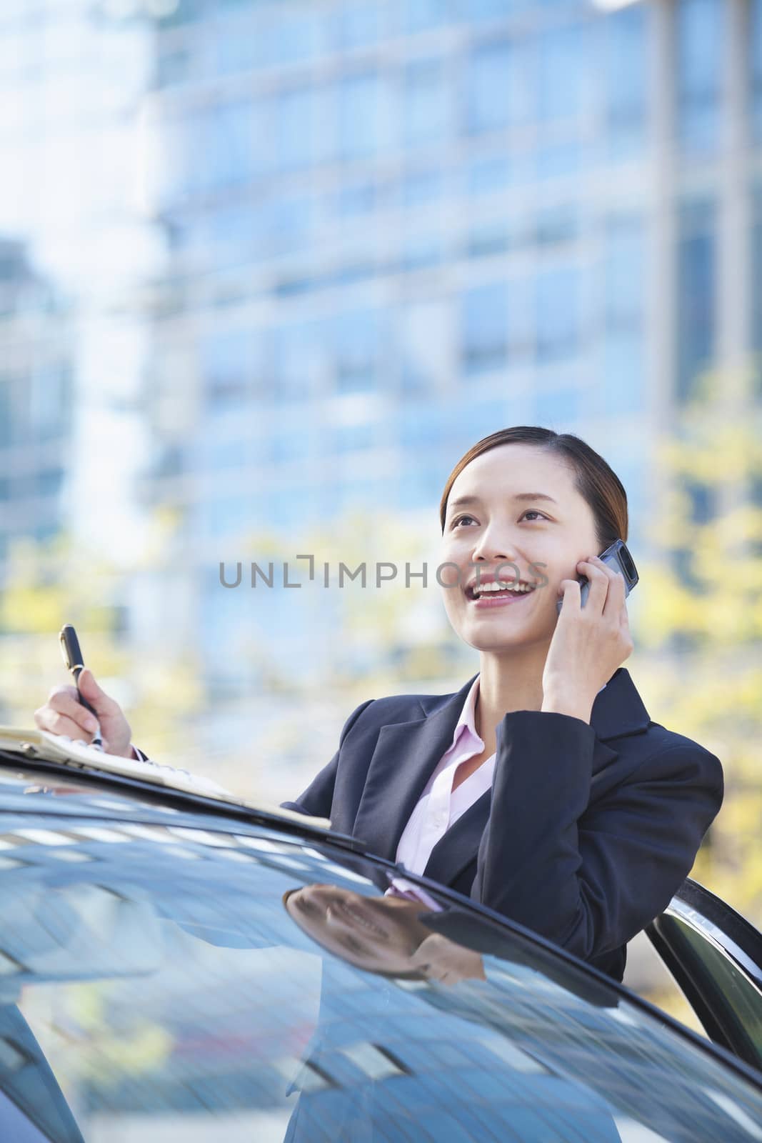 Businesswoman Standing by Car Using Phone by XiXinXing