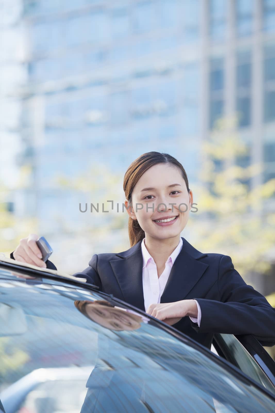 Businesswoman Standing by Car, Looking At Camera