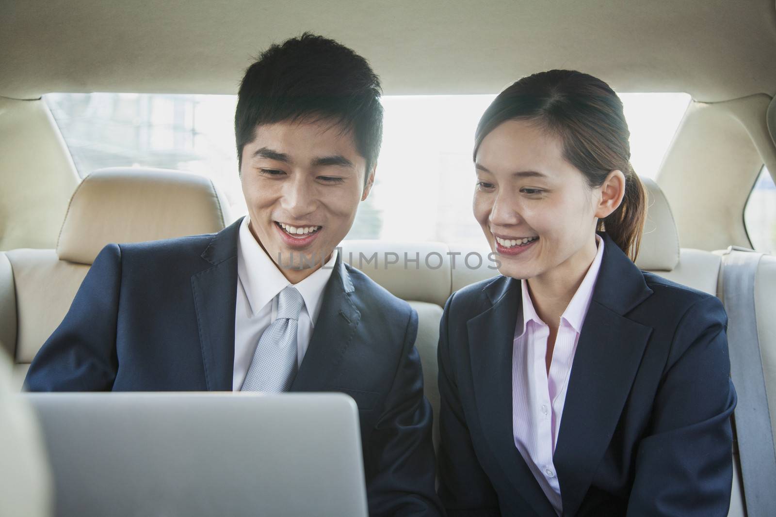 Business People Working in Back Seat of Car by XiXinXing