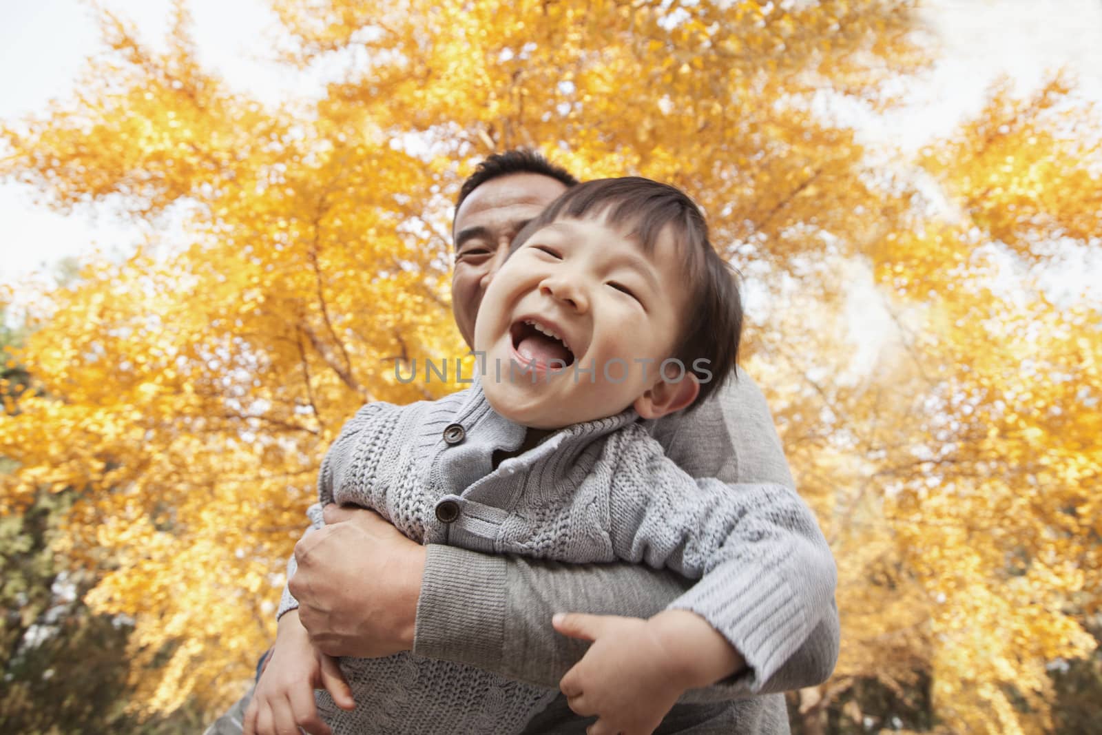 Father and Son Playing a Park in Autumn by XiXinXing
