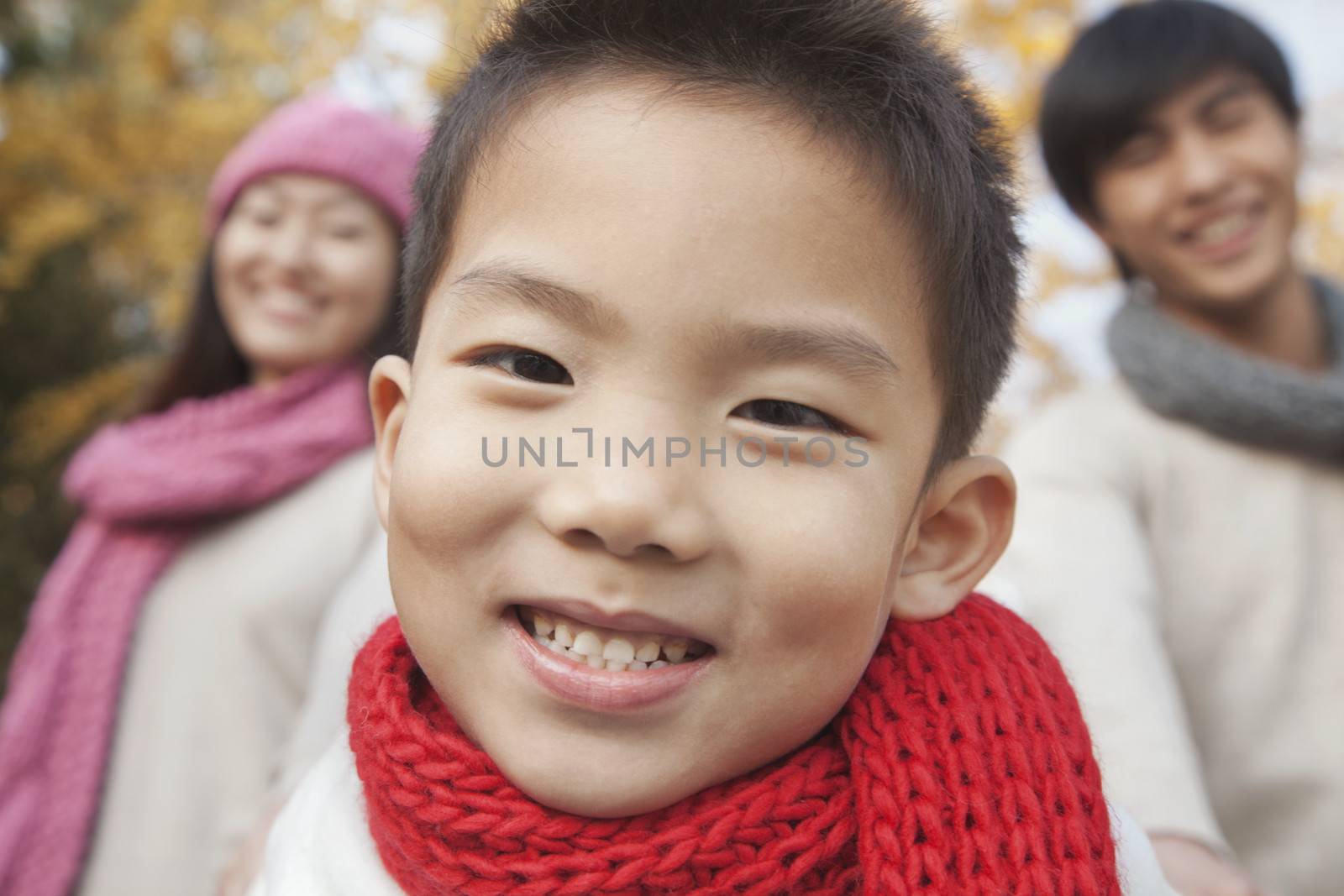 Close Up of Young Boy with Family in Park in Autumn by XiXinXing