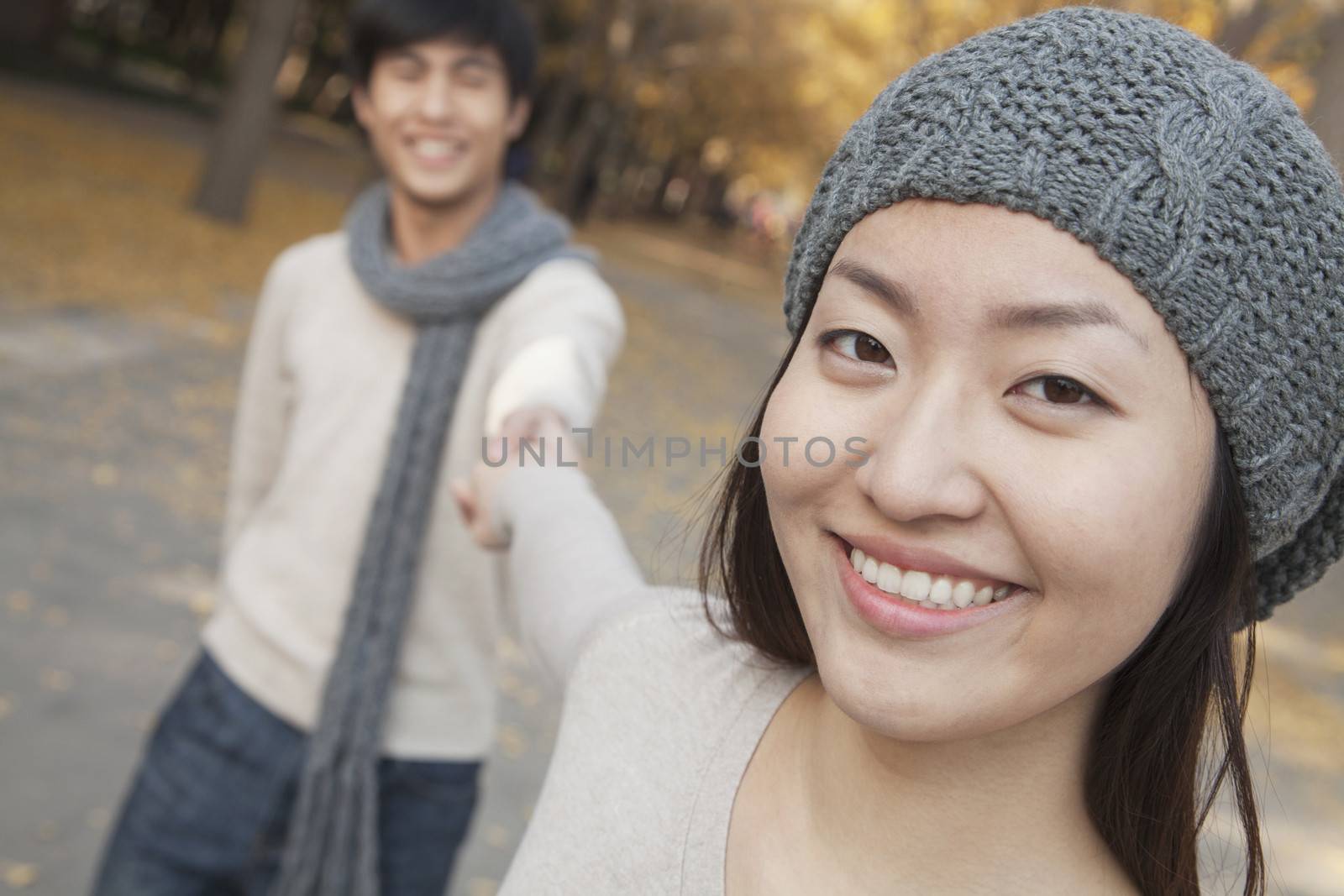 Portrait of Smiling Couple Holding Hands in Park by XiXinXing