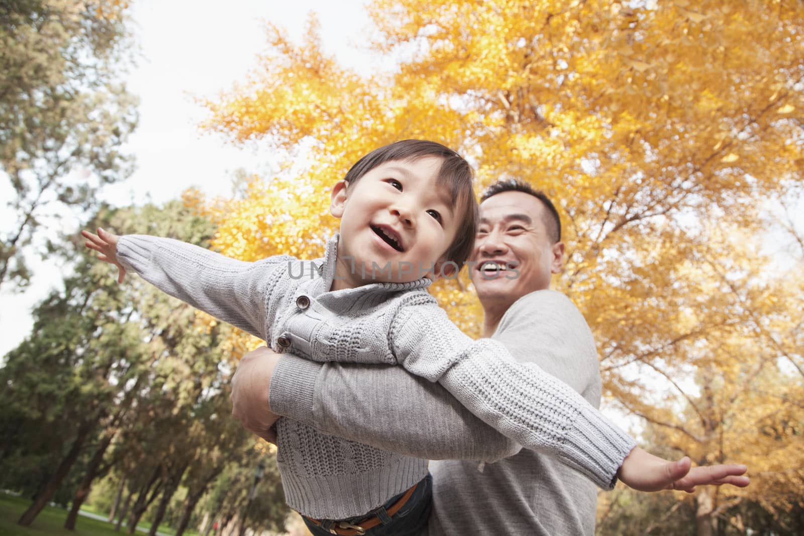 Father and Son Playing at Park in Autumn by XiXinXing