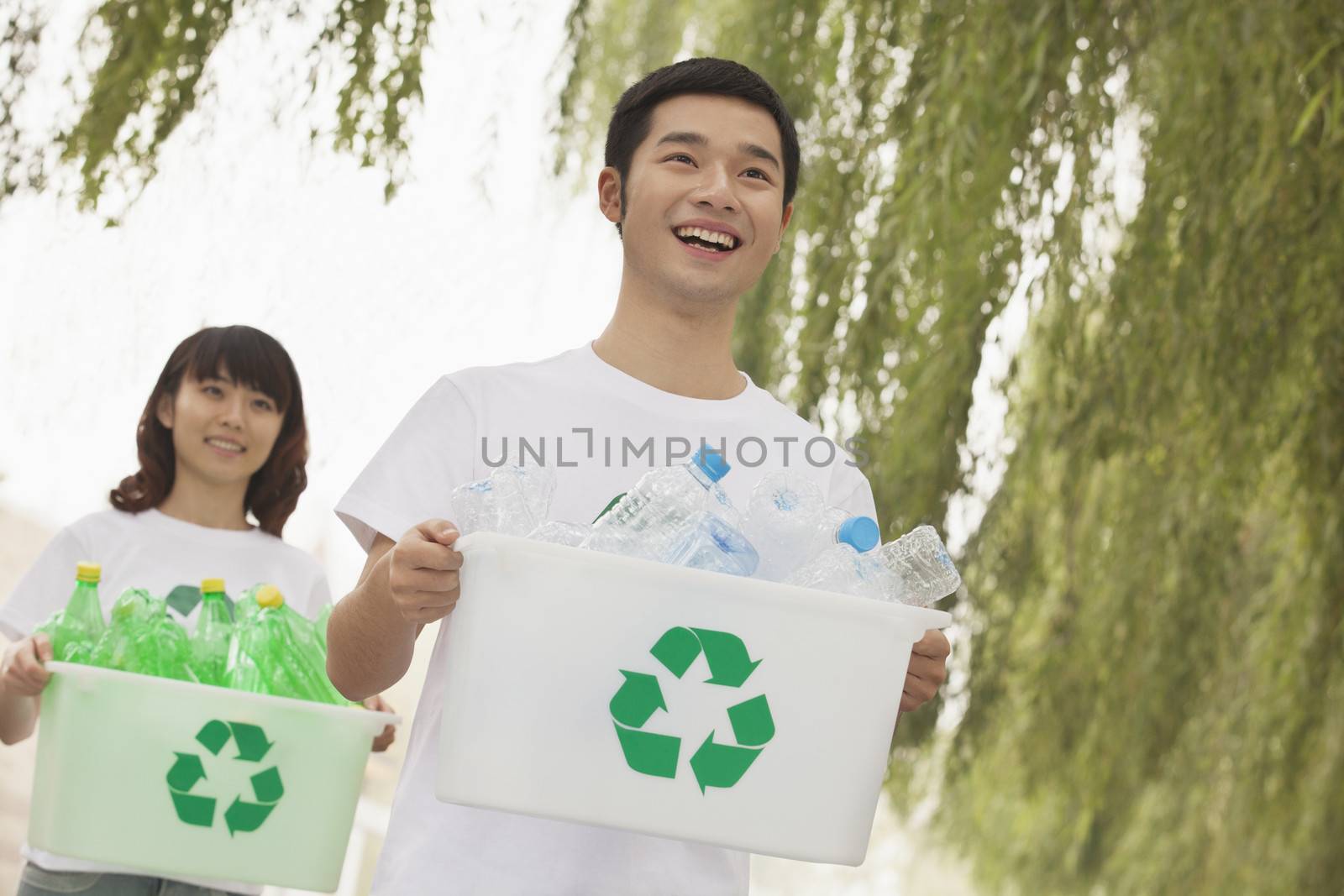 Two Young People Recycling Plastic Bottles