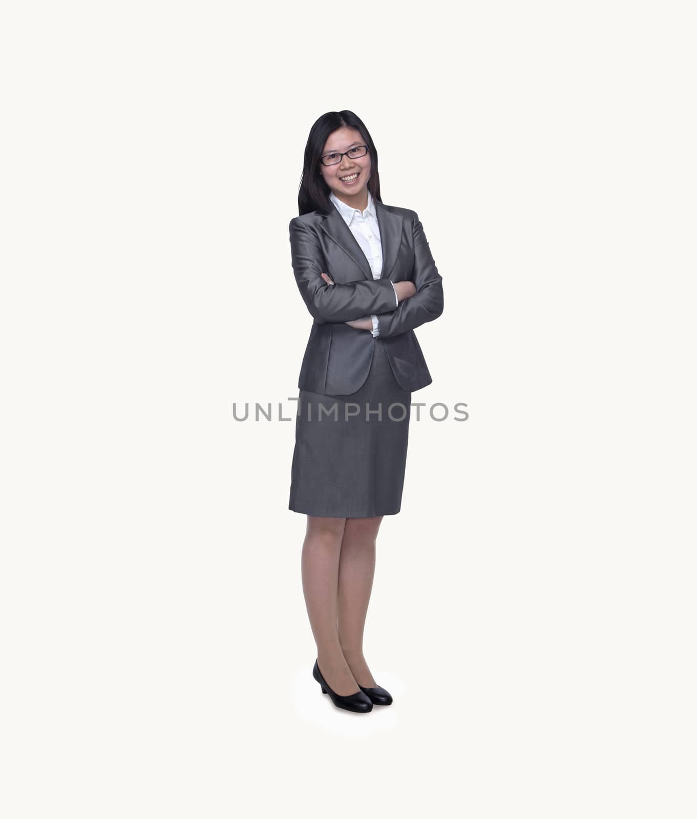 Portrait of smiling young businesswoman with arms crossed, studio shot, full length