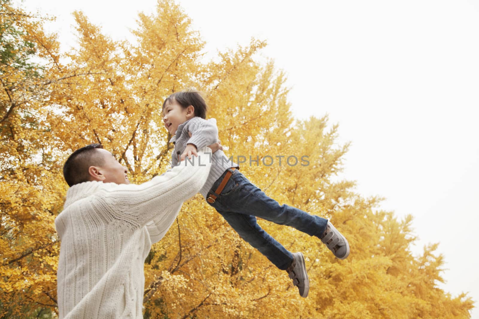 Father And Son Playing a Park in Autumn