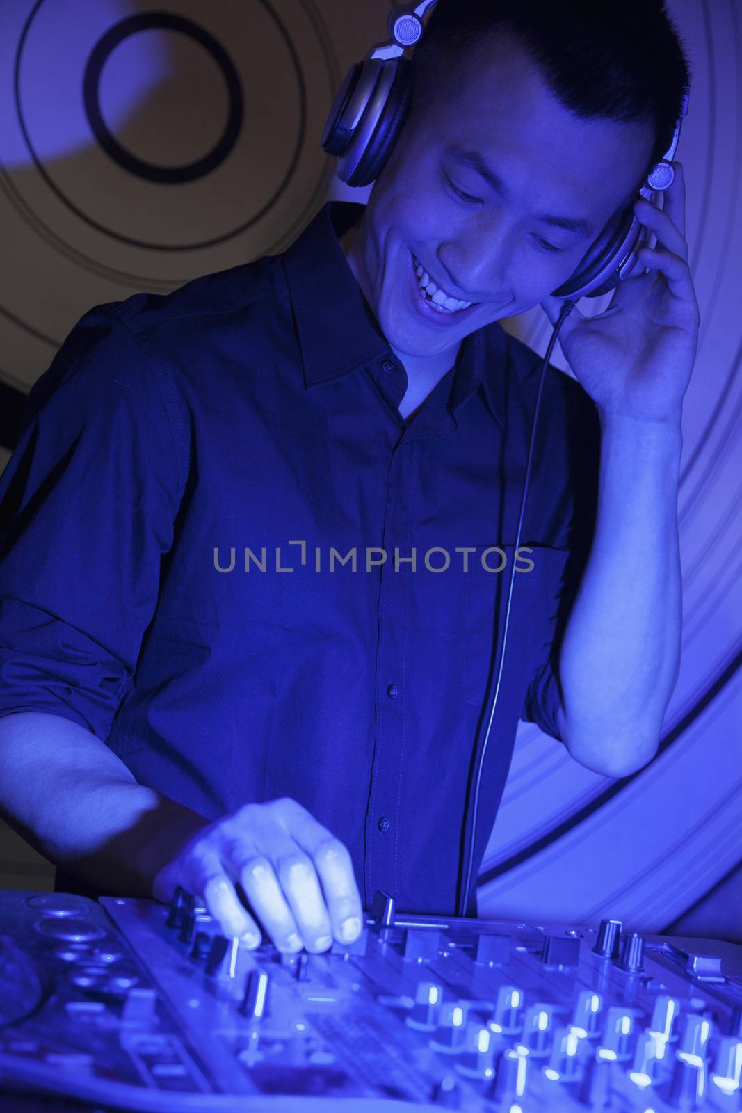 A portrait of a young male DJ playing music in a nightclub by XiXinXing