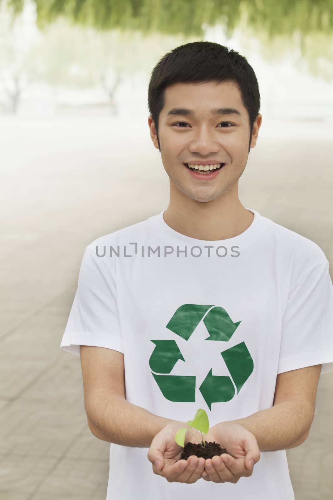 Young Man Holding Seedling in his Hands, Recycling Symbol, Beijing by XiXinXing