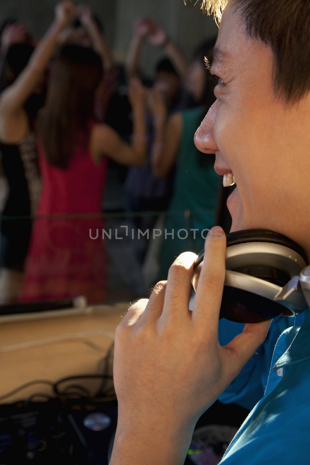 DJ laughing and watching the dancing crowd in nightclub by XiXinXing