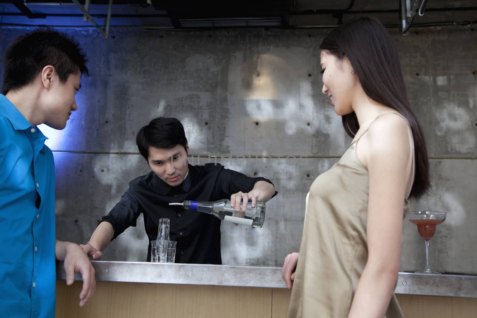 Bartender pouring licour on shot glass pyramid by XiXinXing