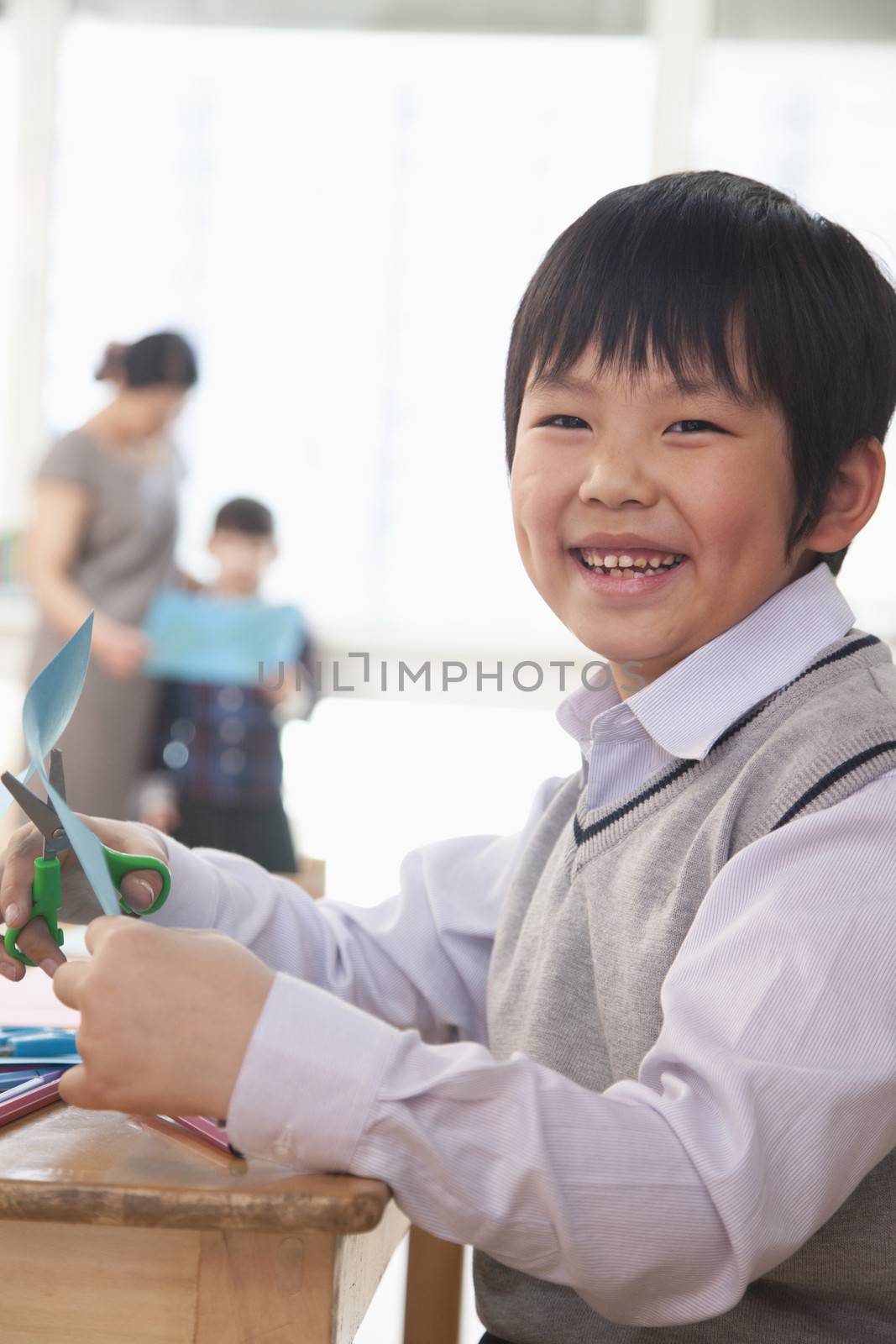 Portrait of Schoolboy doing arts and crafts, Beijing by XiXinXing