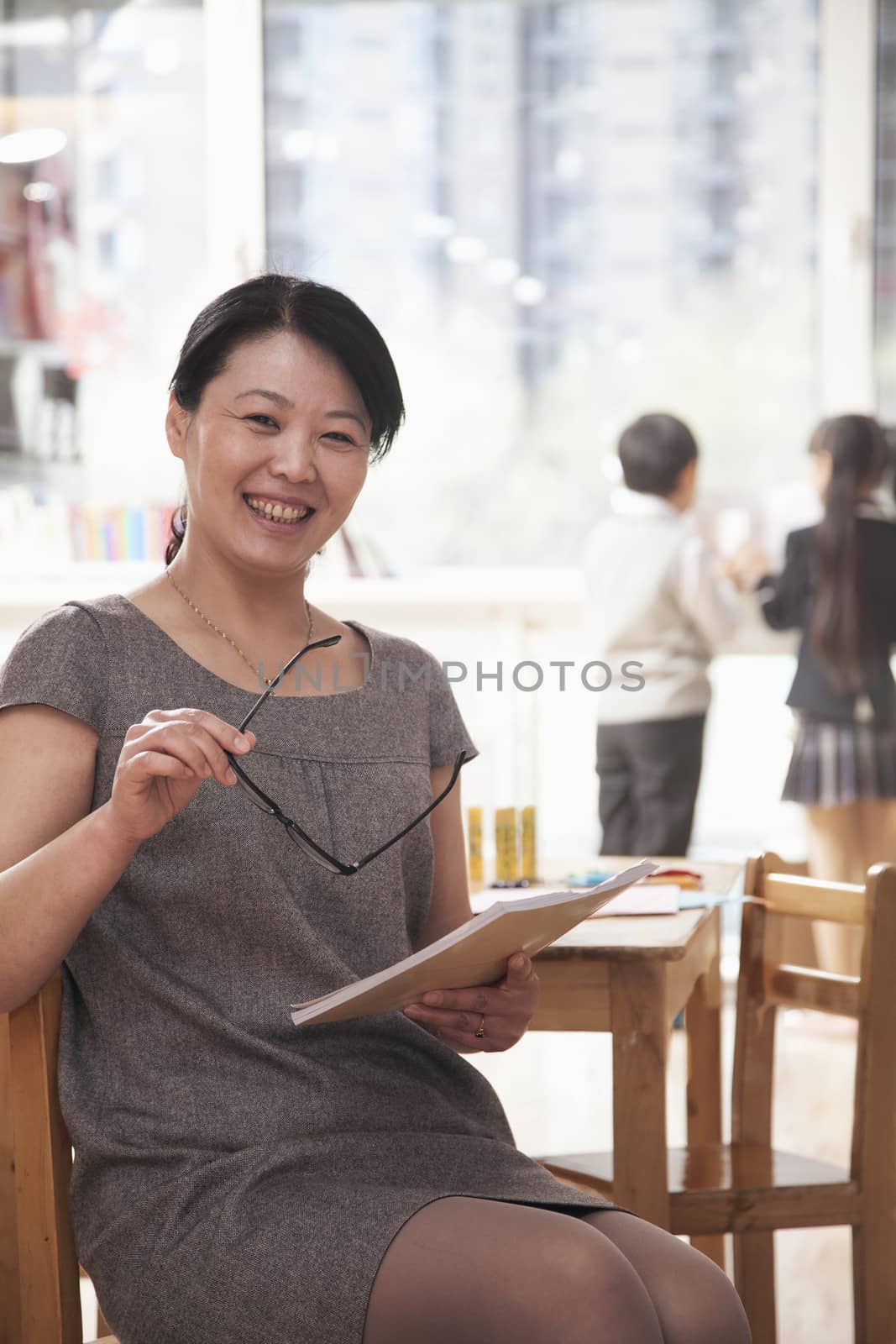 Portrait of smiling teacher in the classroom, Beijing   by XiXinXing