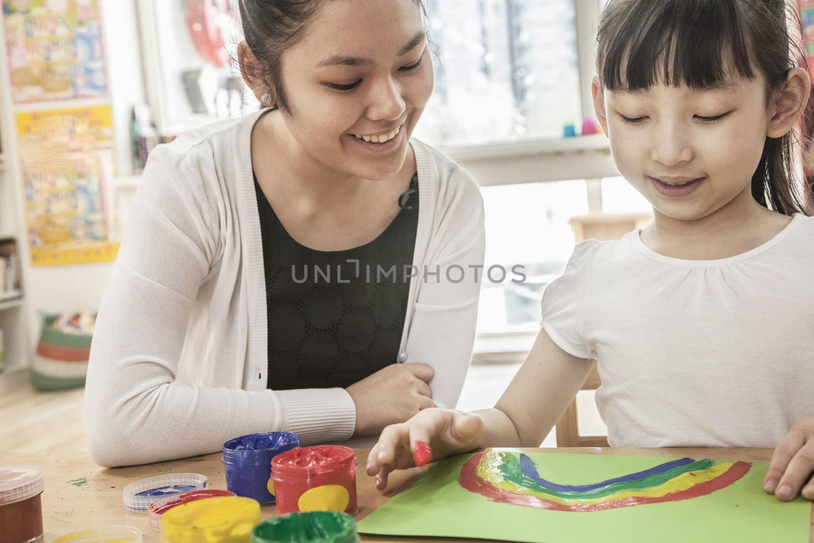 Teacher and student finger painting in art class