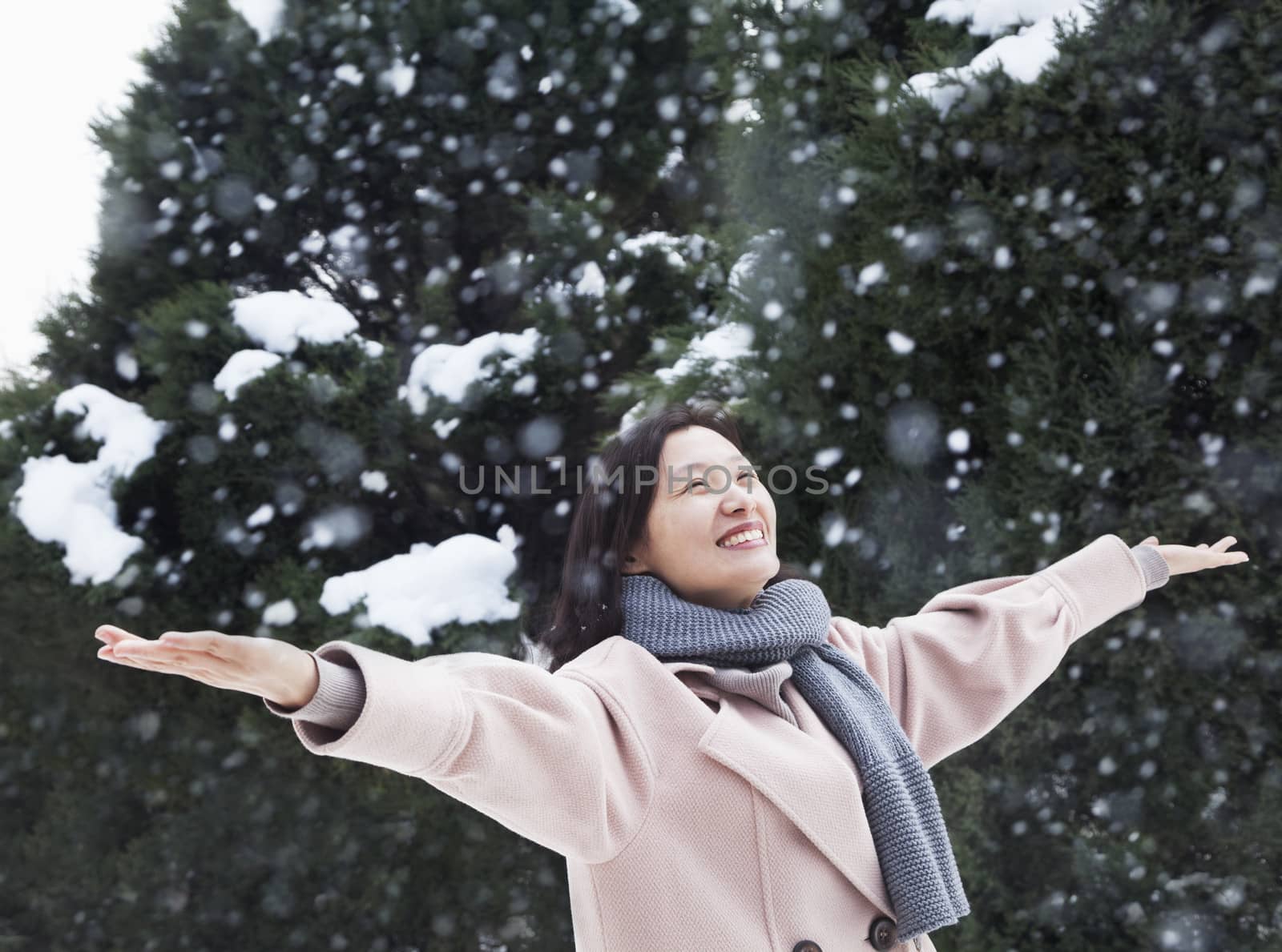 Woman with arms outstretched feeling the snow