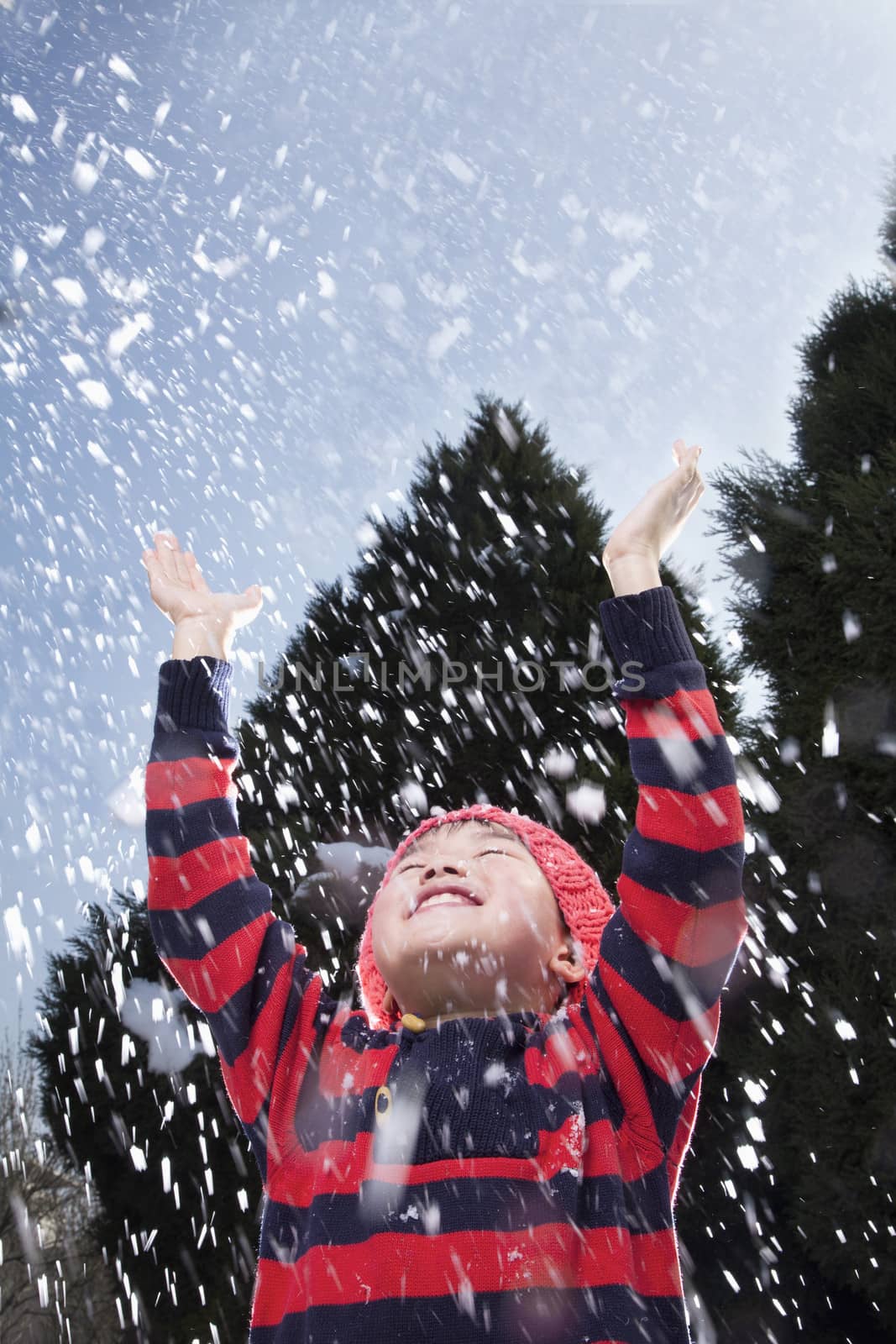 Boy with arms raised feeling the snow by XiXinXing