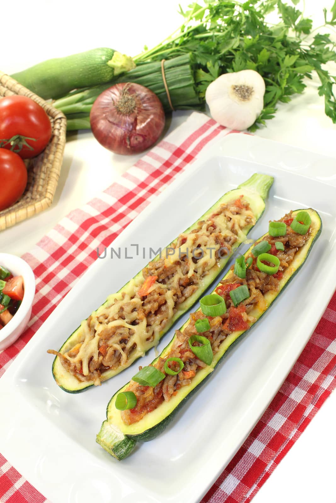 fresh stuffed zucchini with ground beef and cheese on a light background