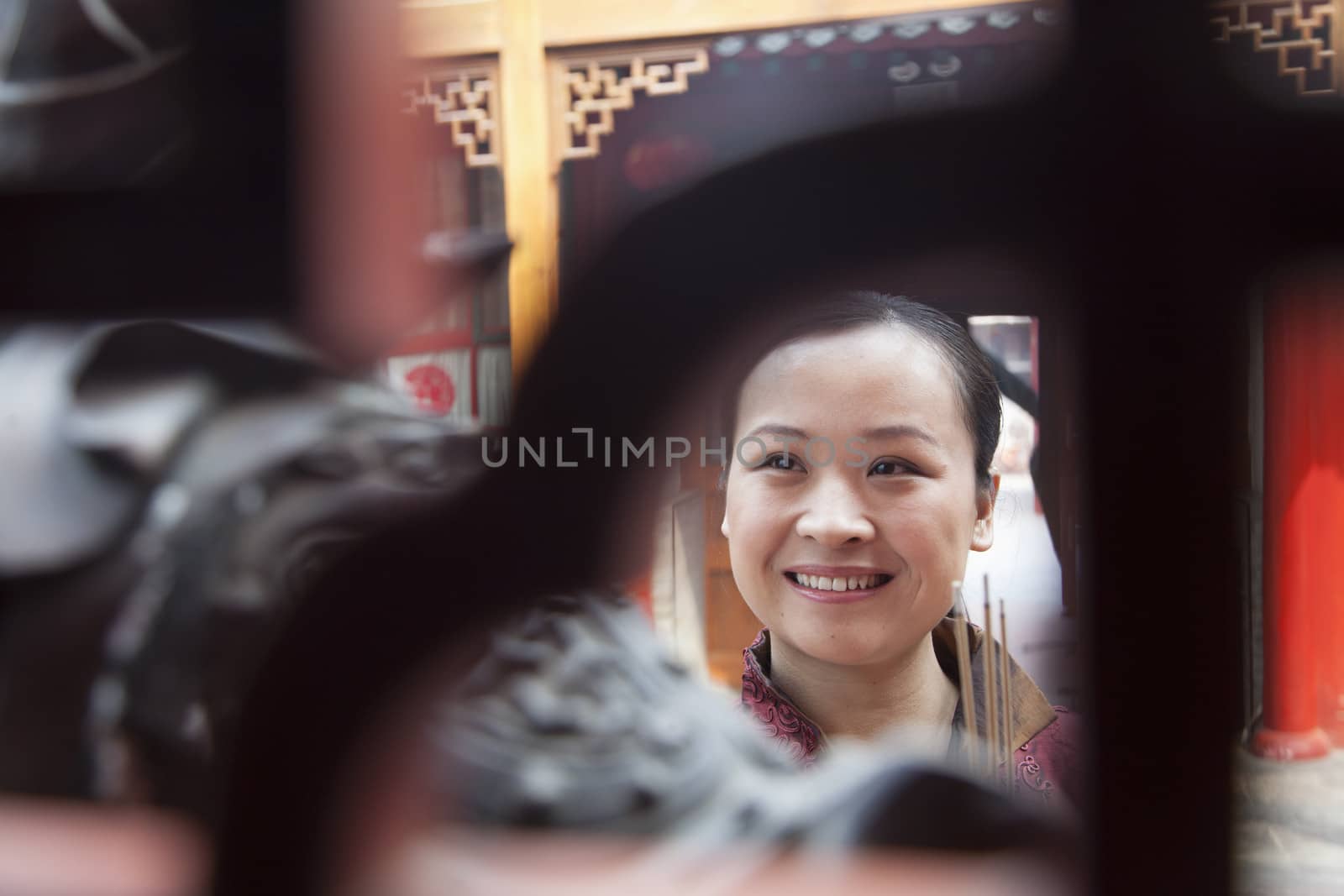 Woman holding incense, temple, Beijing