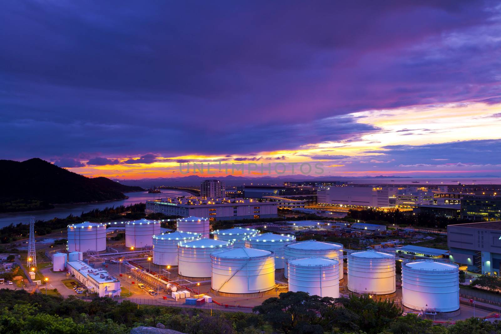 Industrial oil tanks at sunset