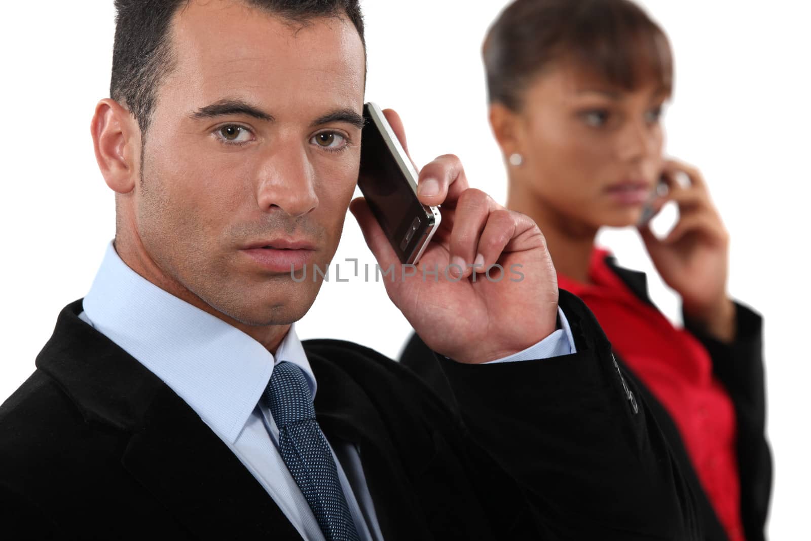 Business professionals talking on their mobile phones by phovoir