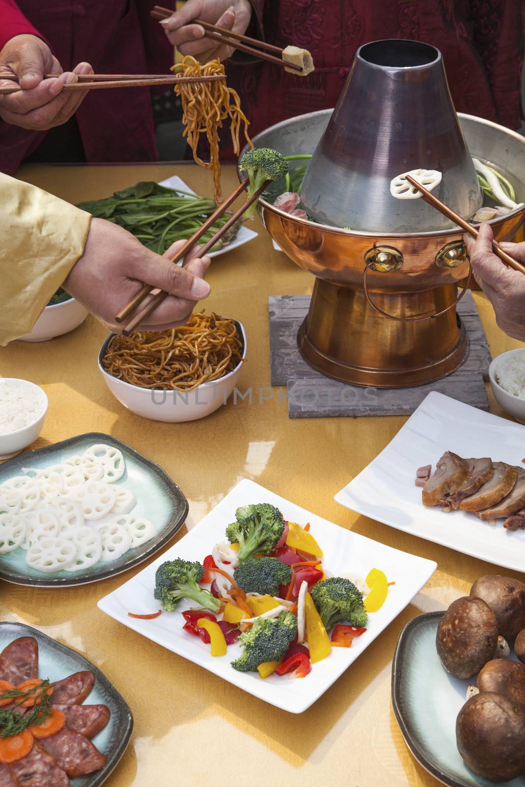 Family eating Chinese hot pot, hands only