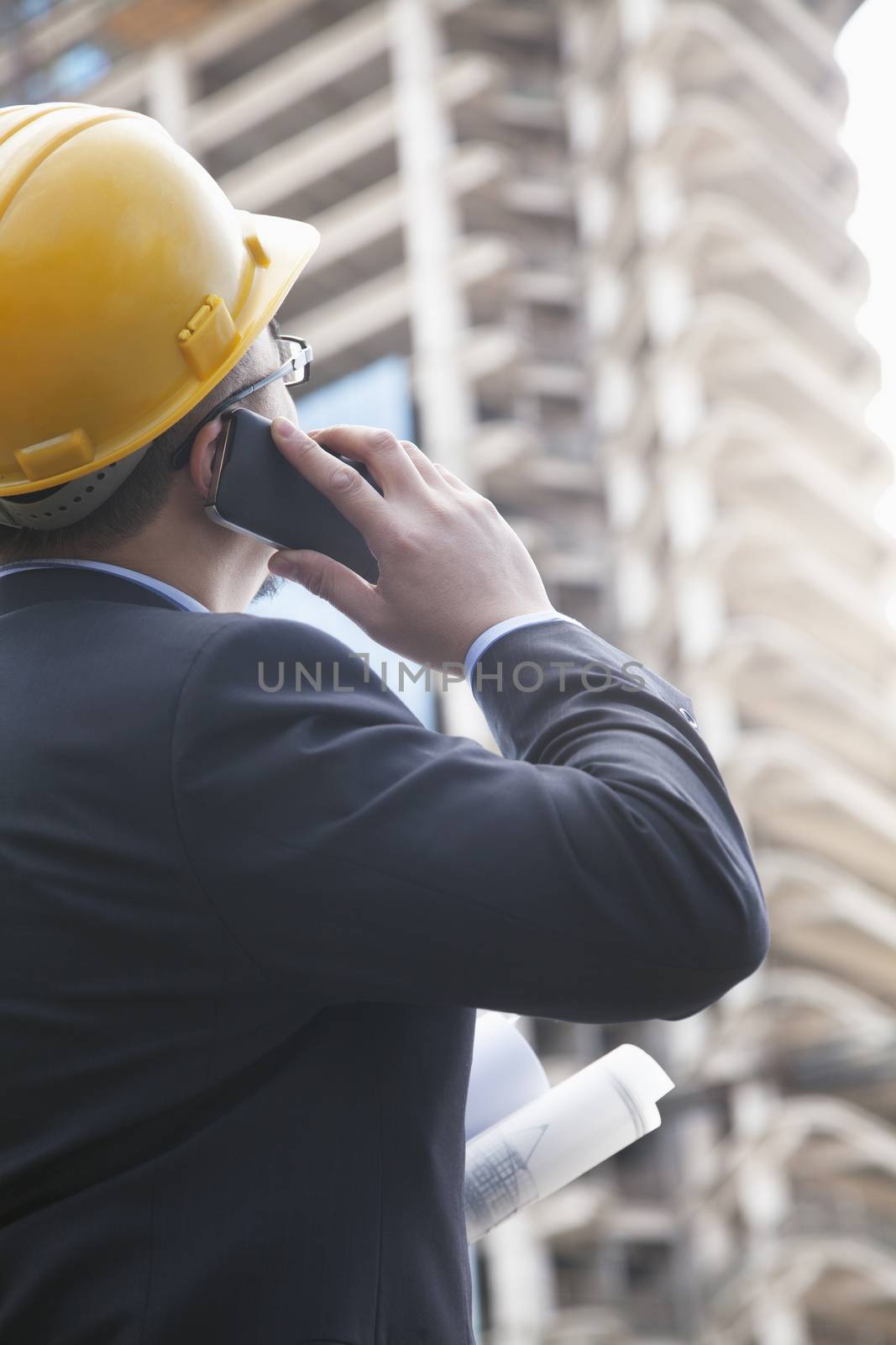 Architect on the phone at a construction site by XiXinXing