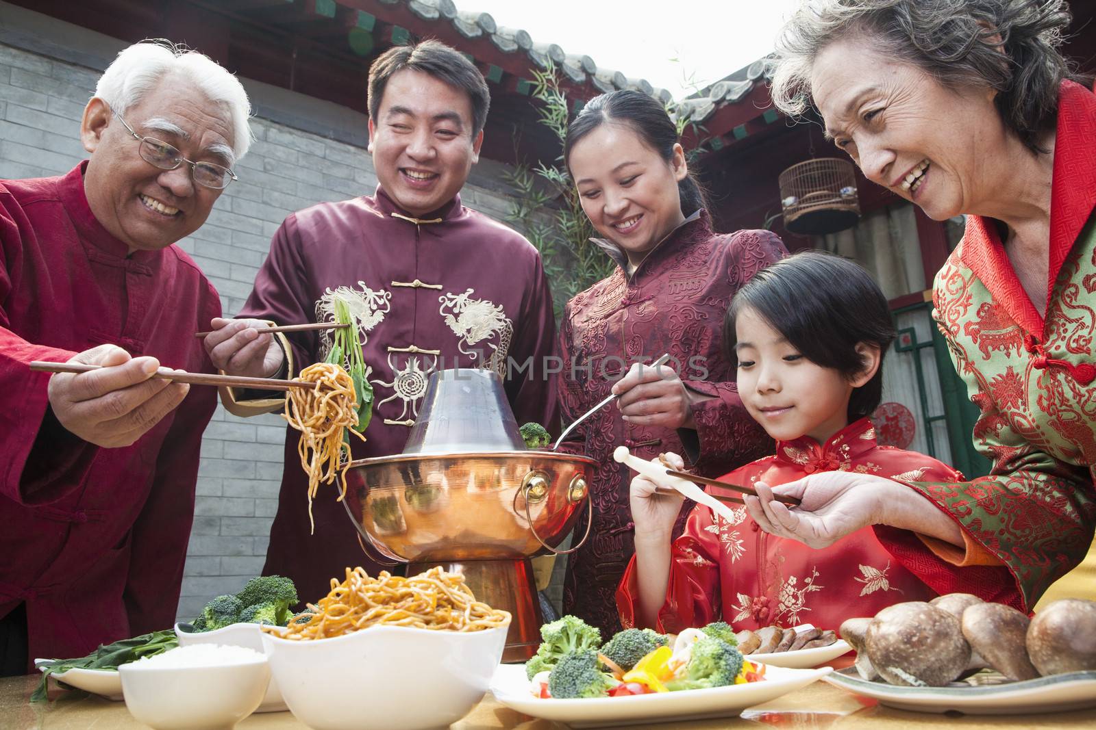 Family enjoying Chinese meal in traditional Chinese clothing by XiXinXing