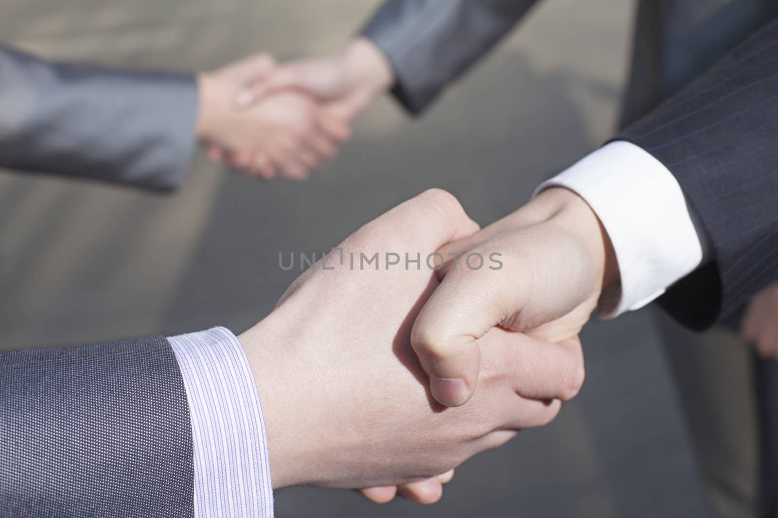  Close up of four business people shaking hands by XiXinXing