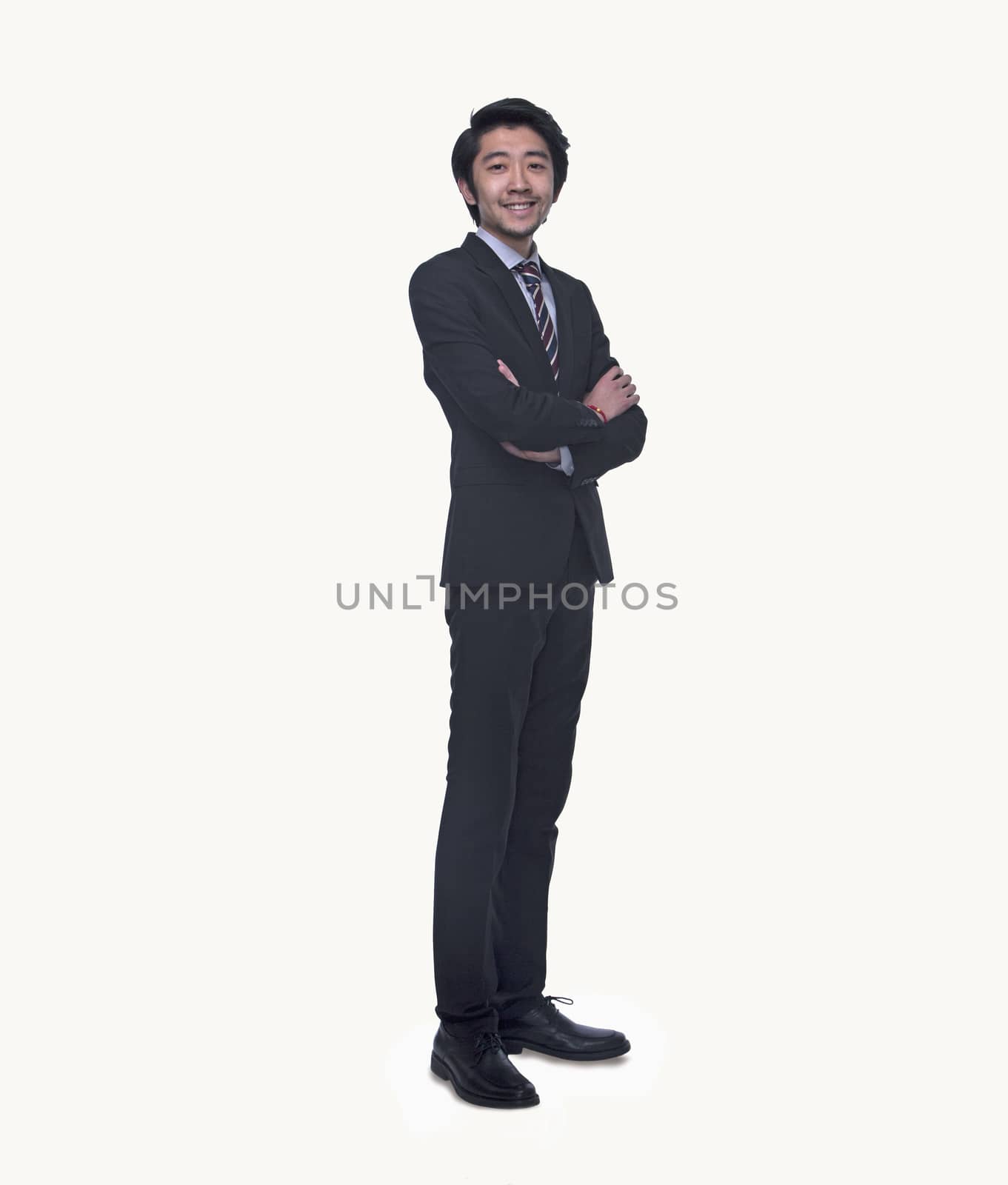 Portrait of smiling young businessman with arms crossed, full length, studio shot