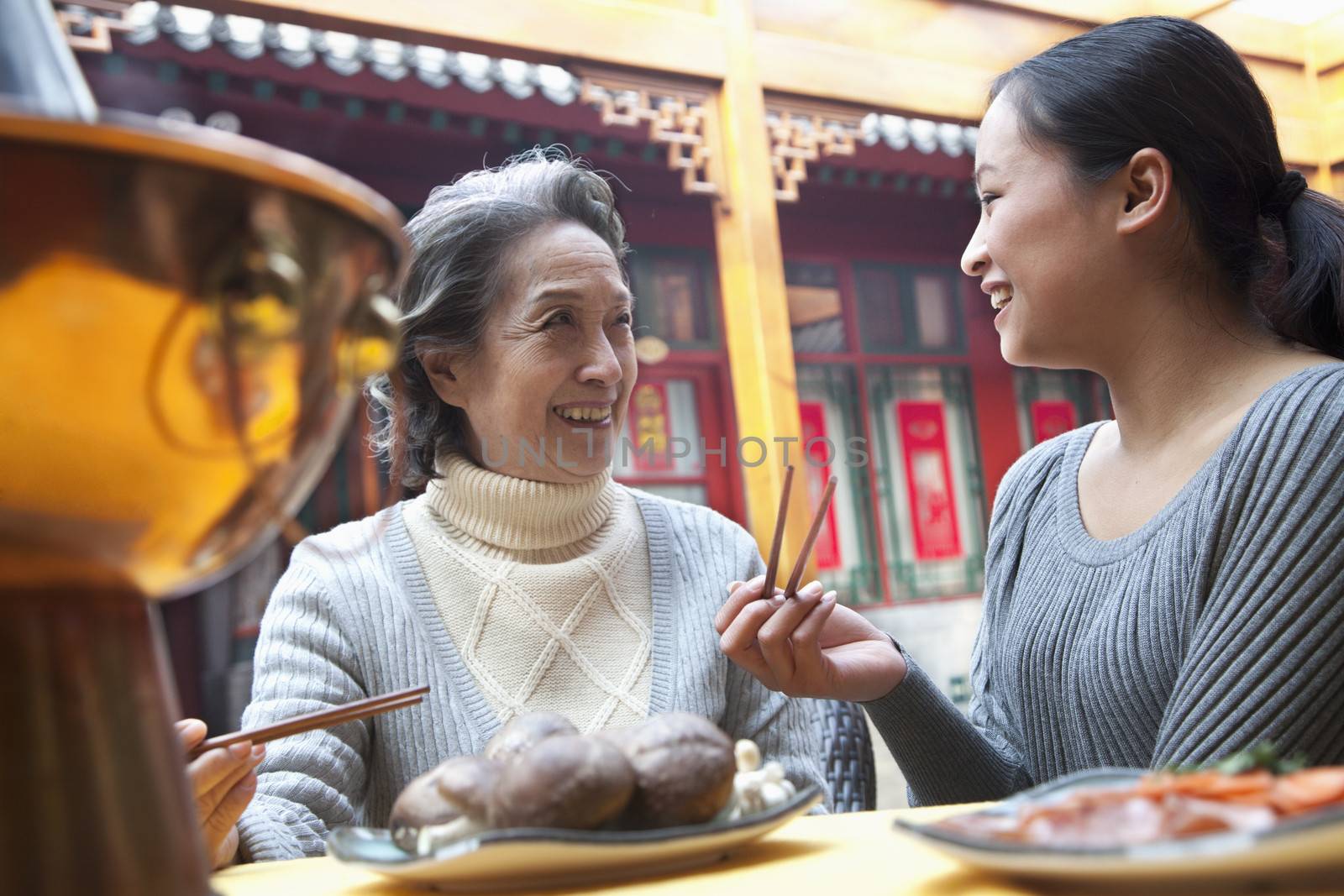 Mother and adult daughter enjoying traditional Chinese meal