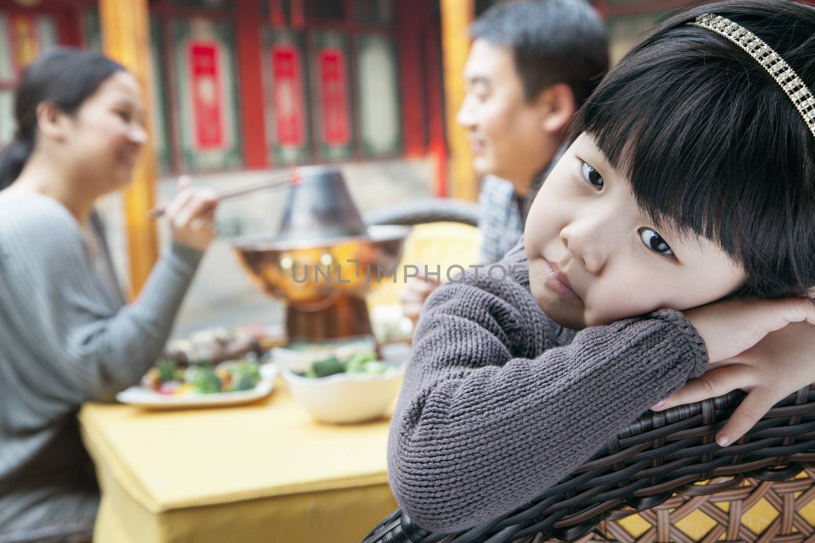 Portrait of tired little girl at family meal by XiXinXing