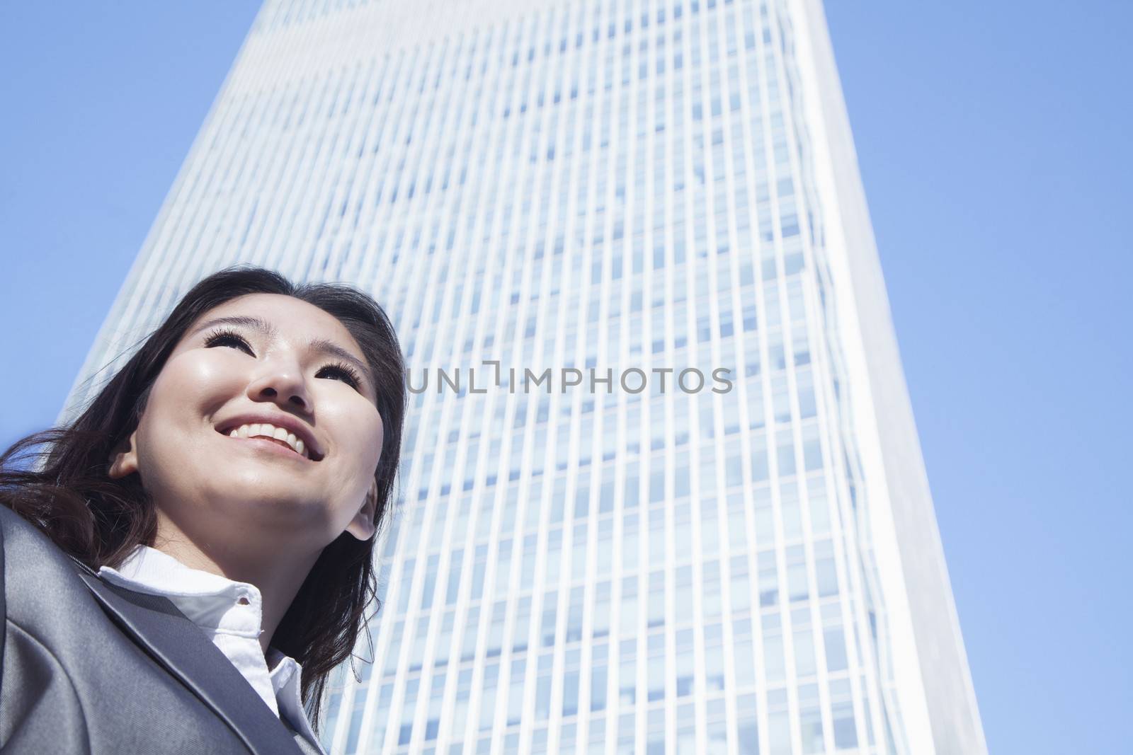 Portrait of young businesswoman by Chinas world trade center building in Beijing by XiXinXing