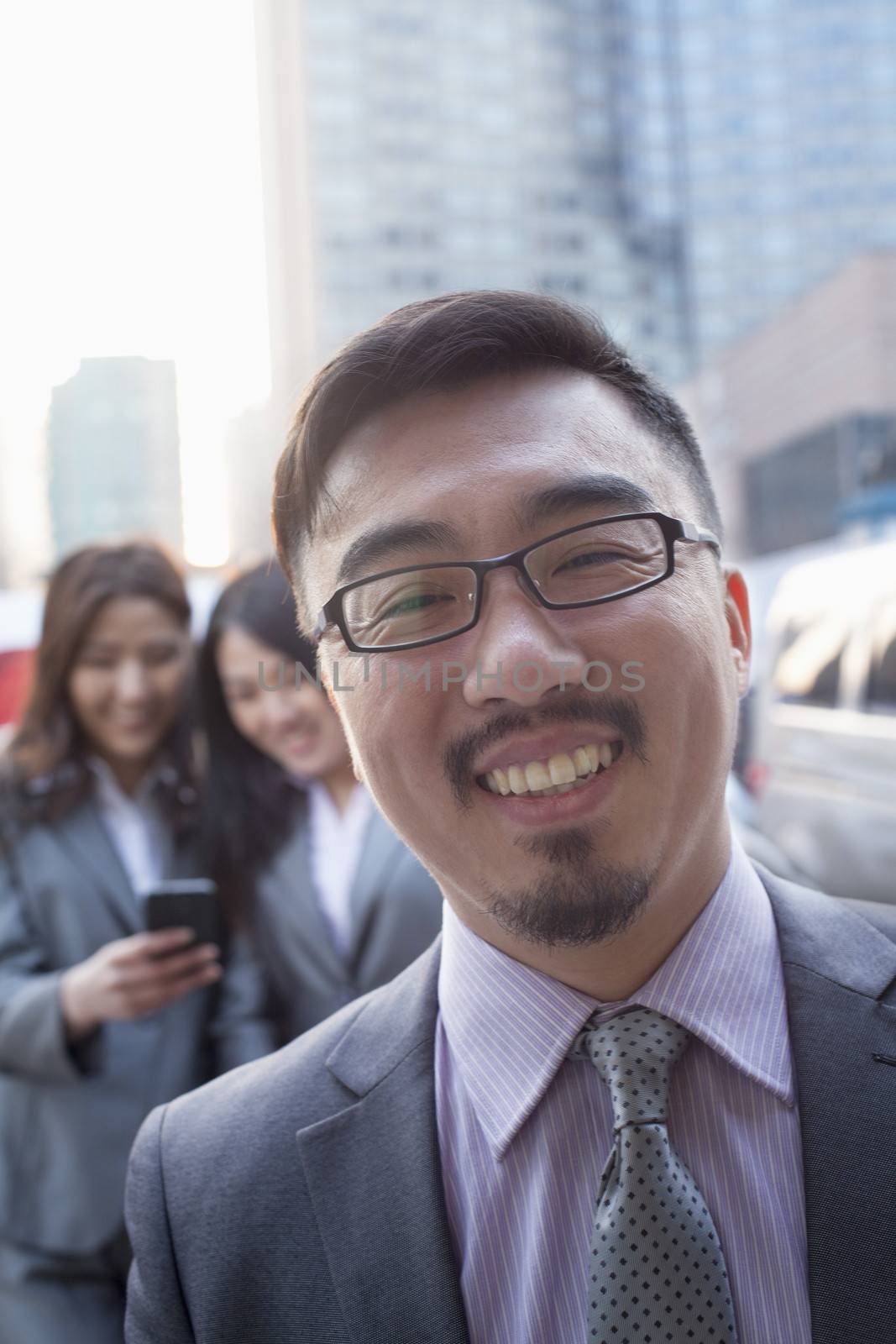 Portrait of smiling businessman outdoors, Beijing   by XiXinXing