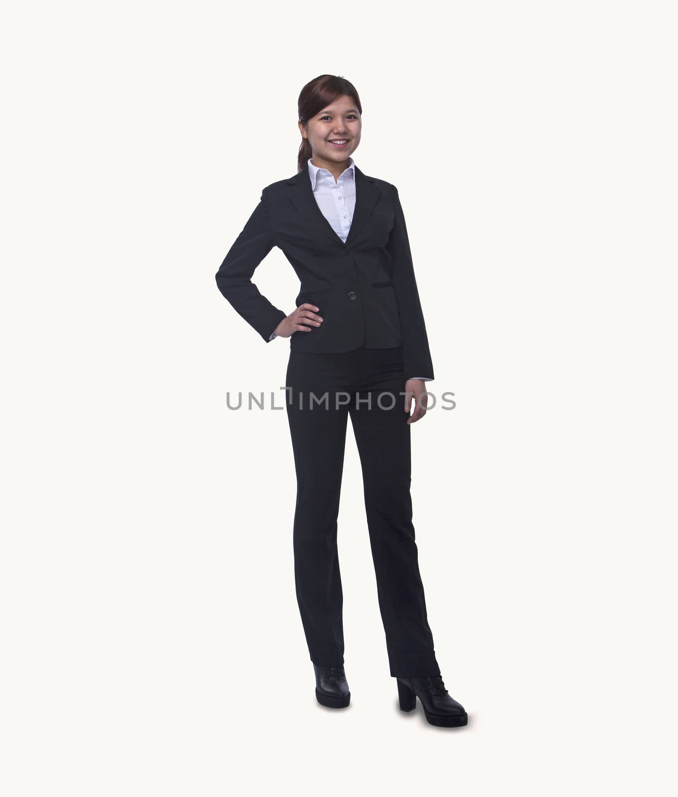 Portrait of smiling young businesswoman with hand on hip looking at camera,  full length, studio shot by XiXinXing