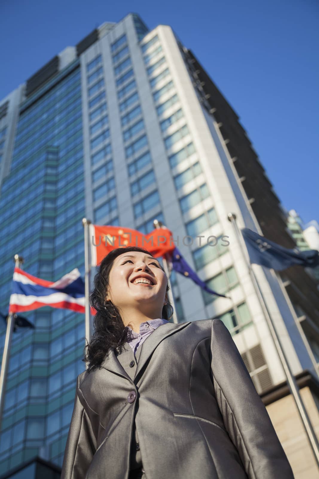 Low angle view of businesswoman in front of a building with Chinese flag in the background