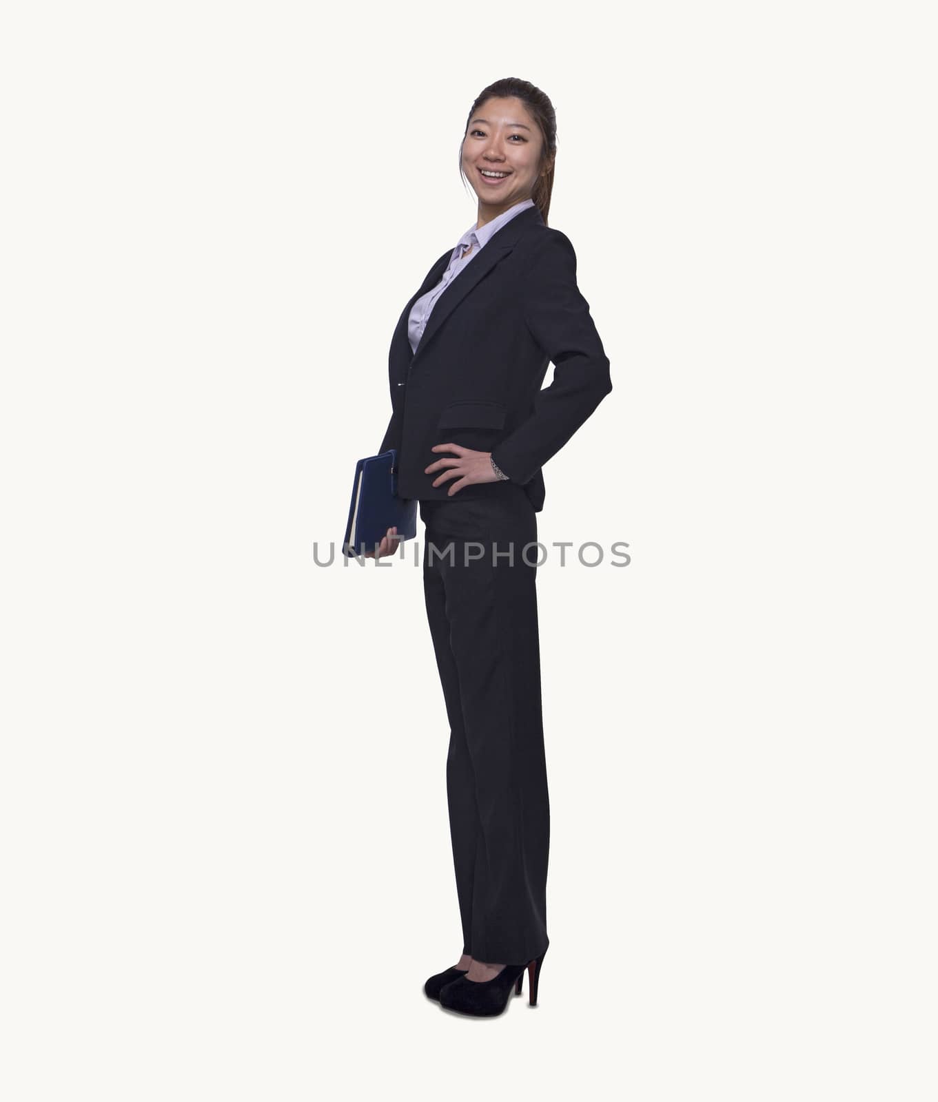 Portrait of smiling young businesswoman holding her personal organizer, full length, studio shot