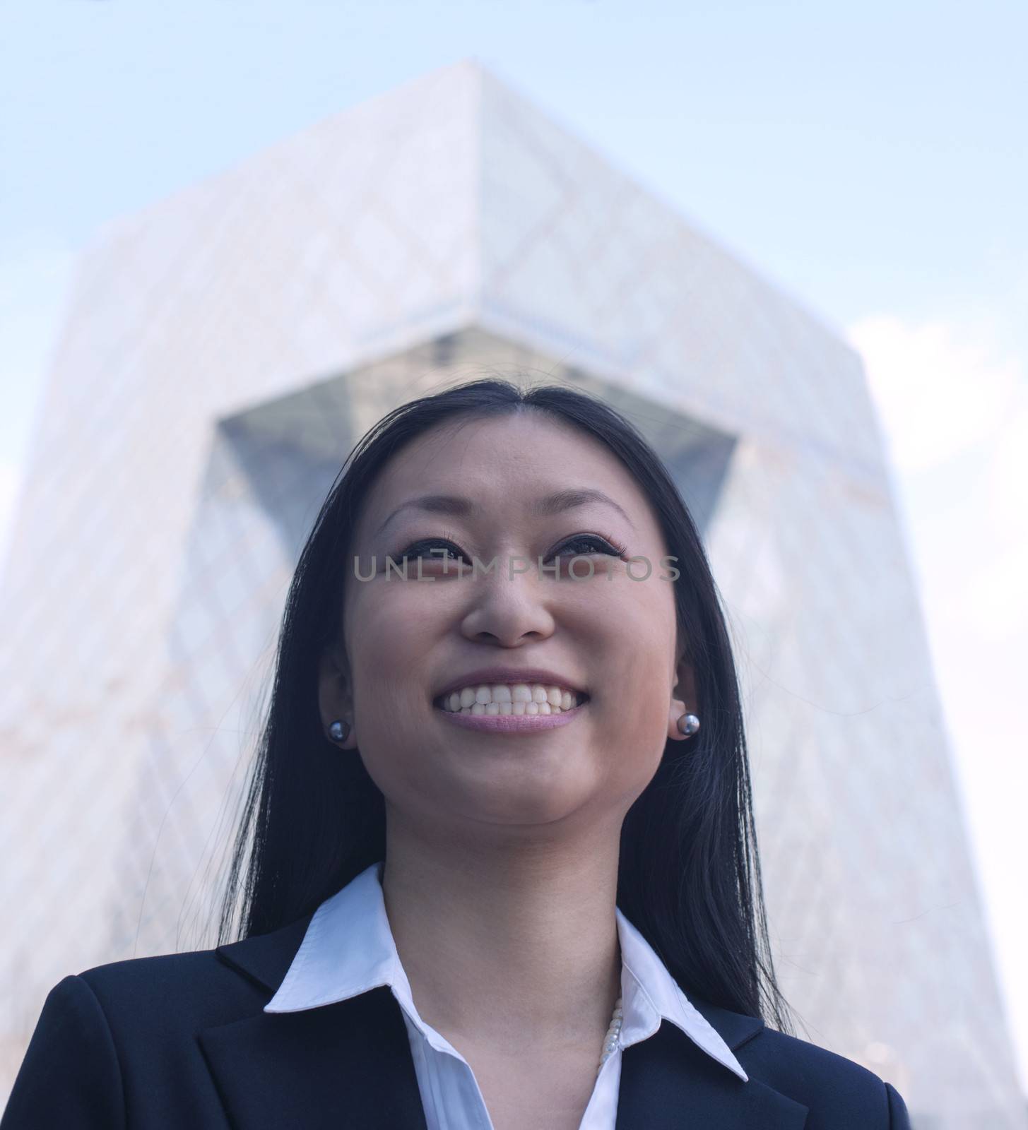 Portrait of smiling young businesswoman with the CCTV building in background, Beijing