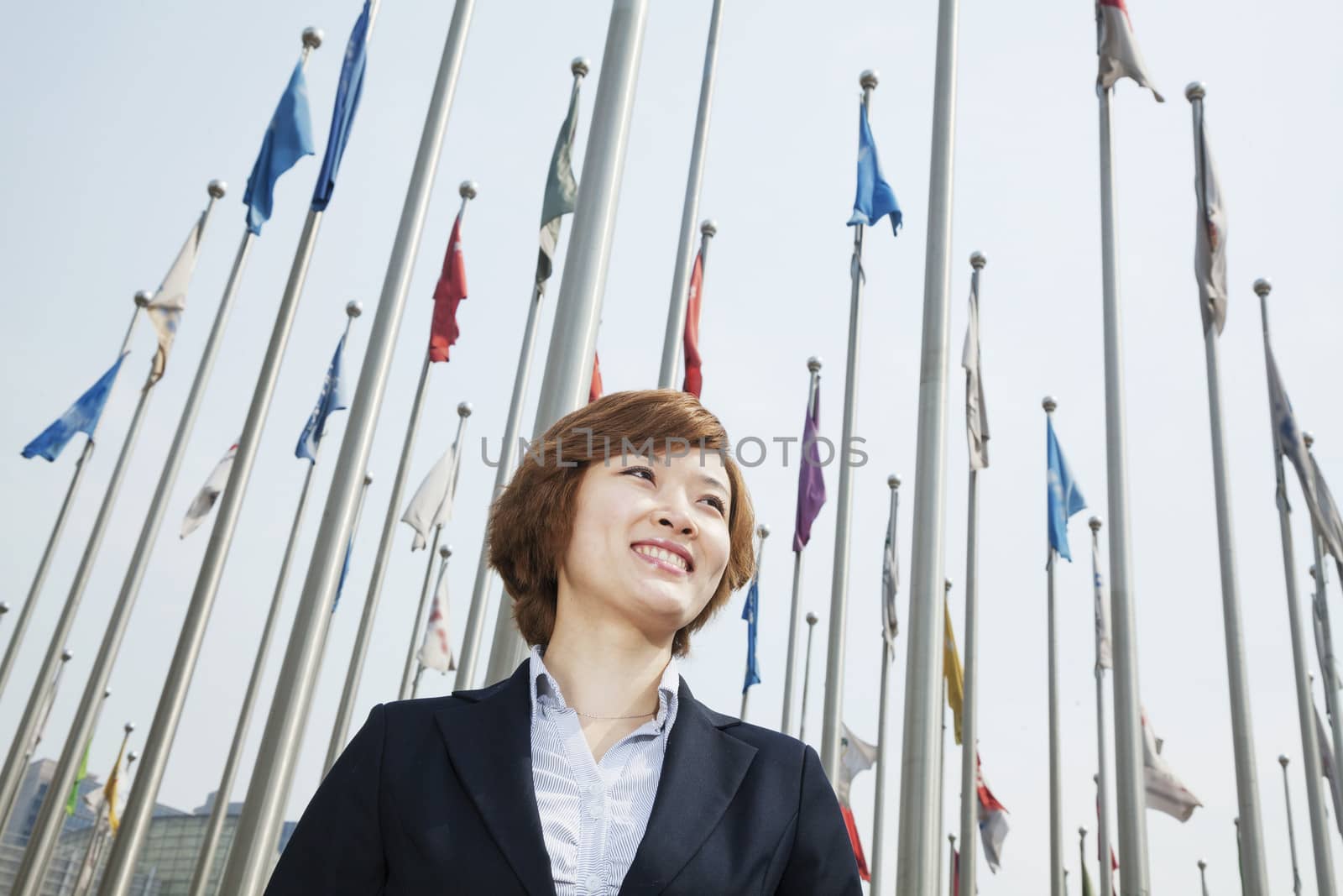 Portrait of smiling young businesswoman with flags by XiXinXing