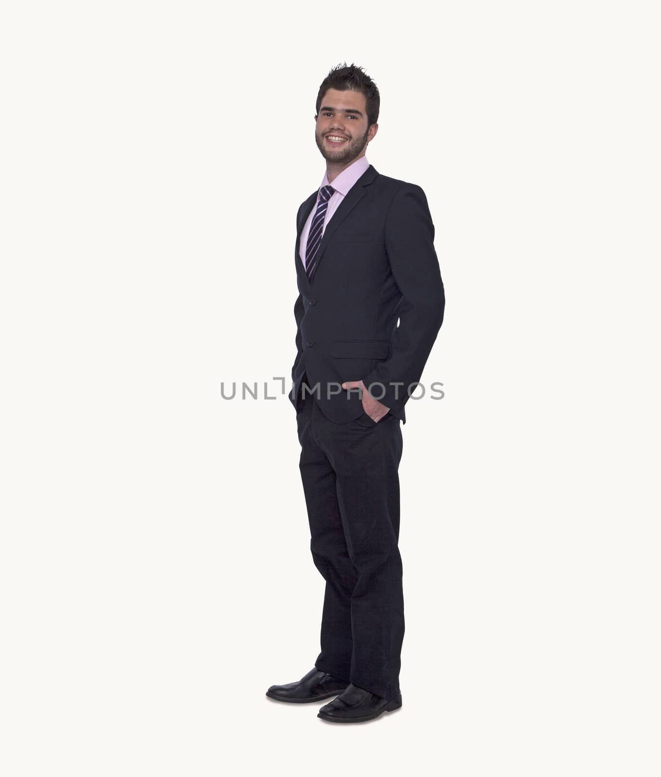 Portrait of smiling young businessman with hands in his pockets, studio shot, full length by XiXinXing
